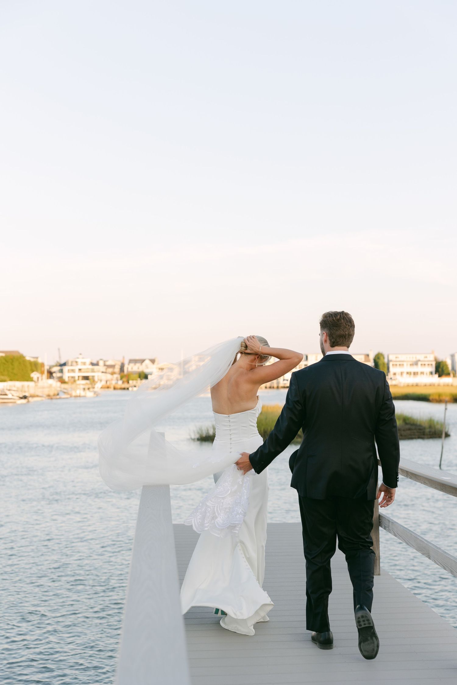 A wedding photographer photographs a Bride and groom celebrating their wedding at sunset at a private estate in Avalon New Jersey.