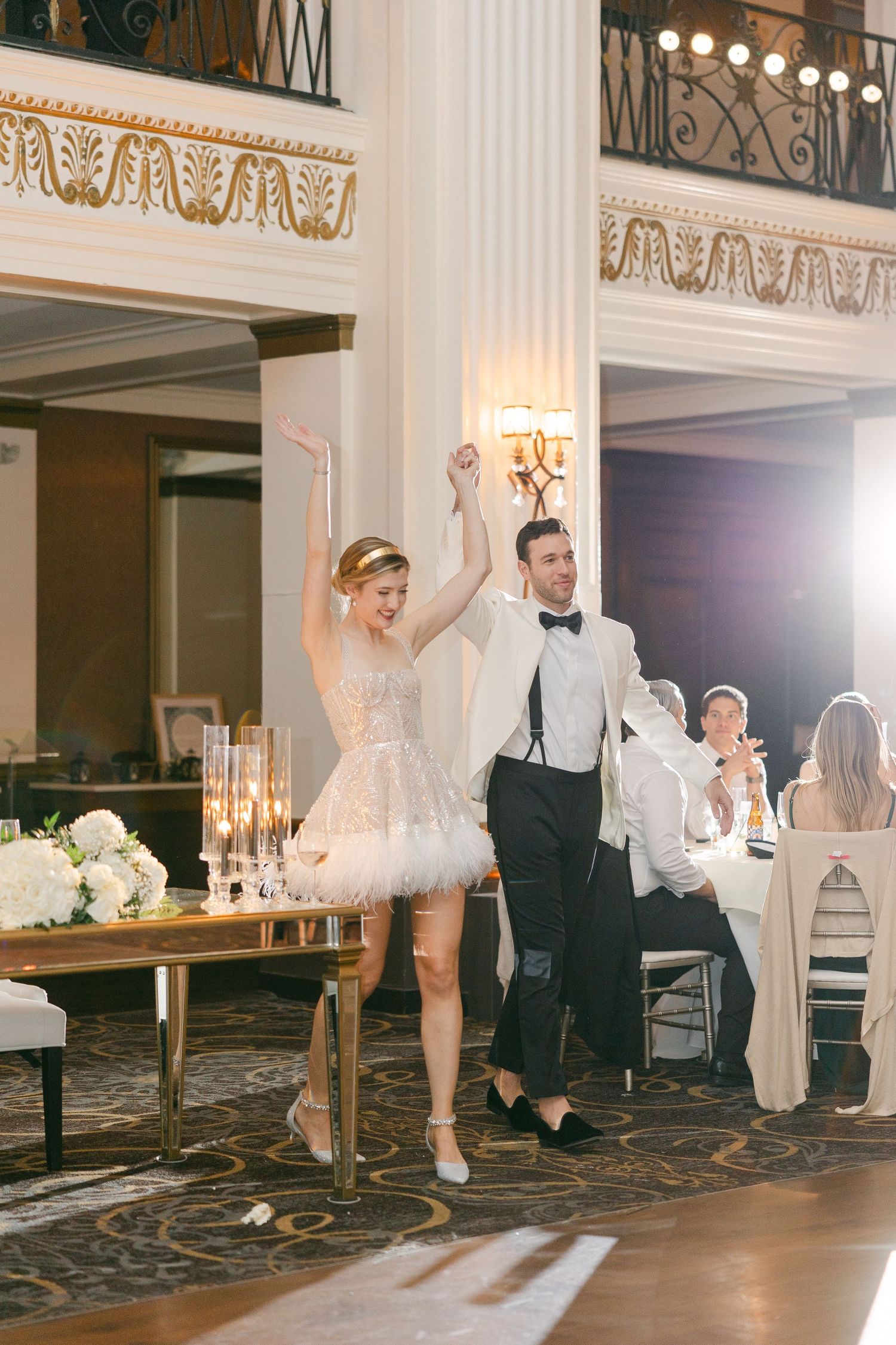 bride and groom dance and celebrate on an elegant ballroom floor in philadelphia illuminated by chandeliers and soft lighting.