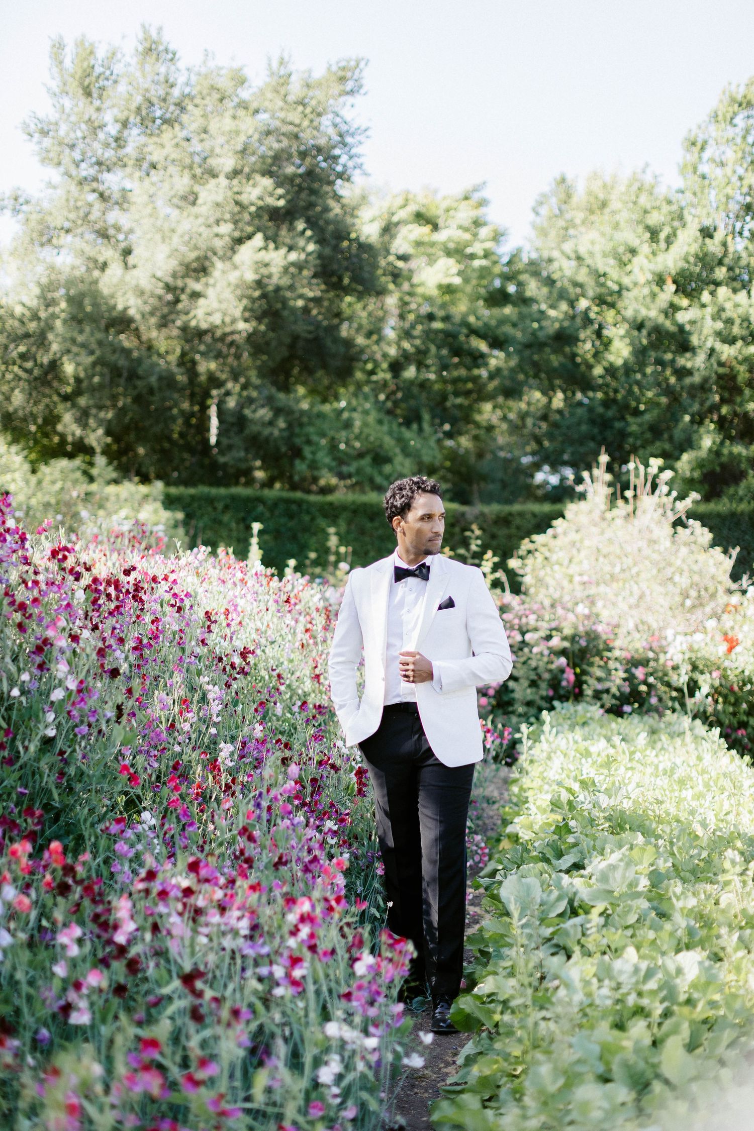 A garden wedding setting with vibrant pink and purple flowers creating a romantic backdrop.
