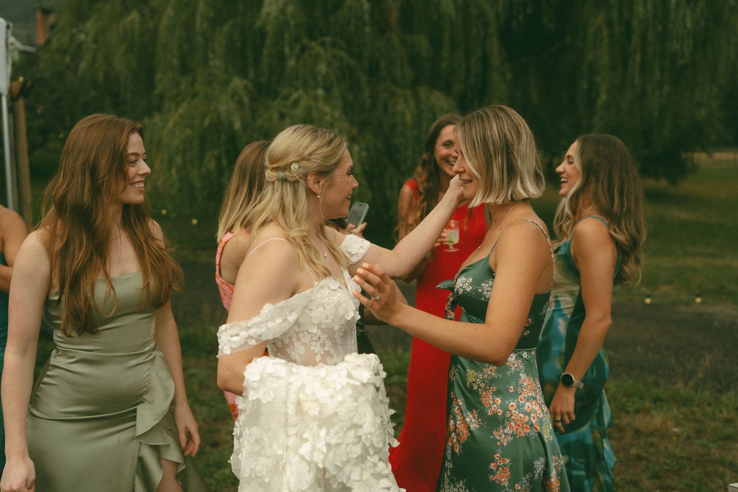 Wedding party celebrating outdoors with mountains and trees in the background.