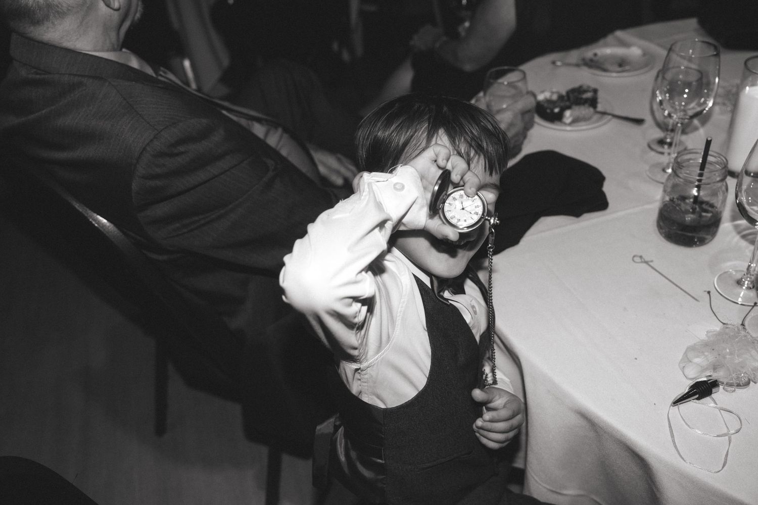 Black and white reception photos showing guests interacting at dining tables.