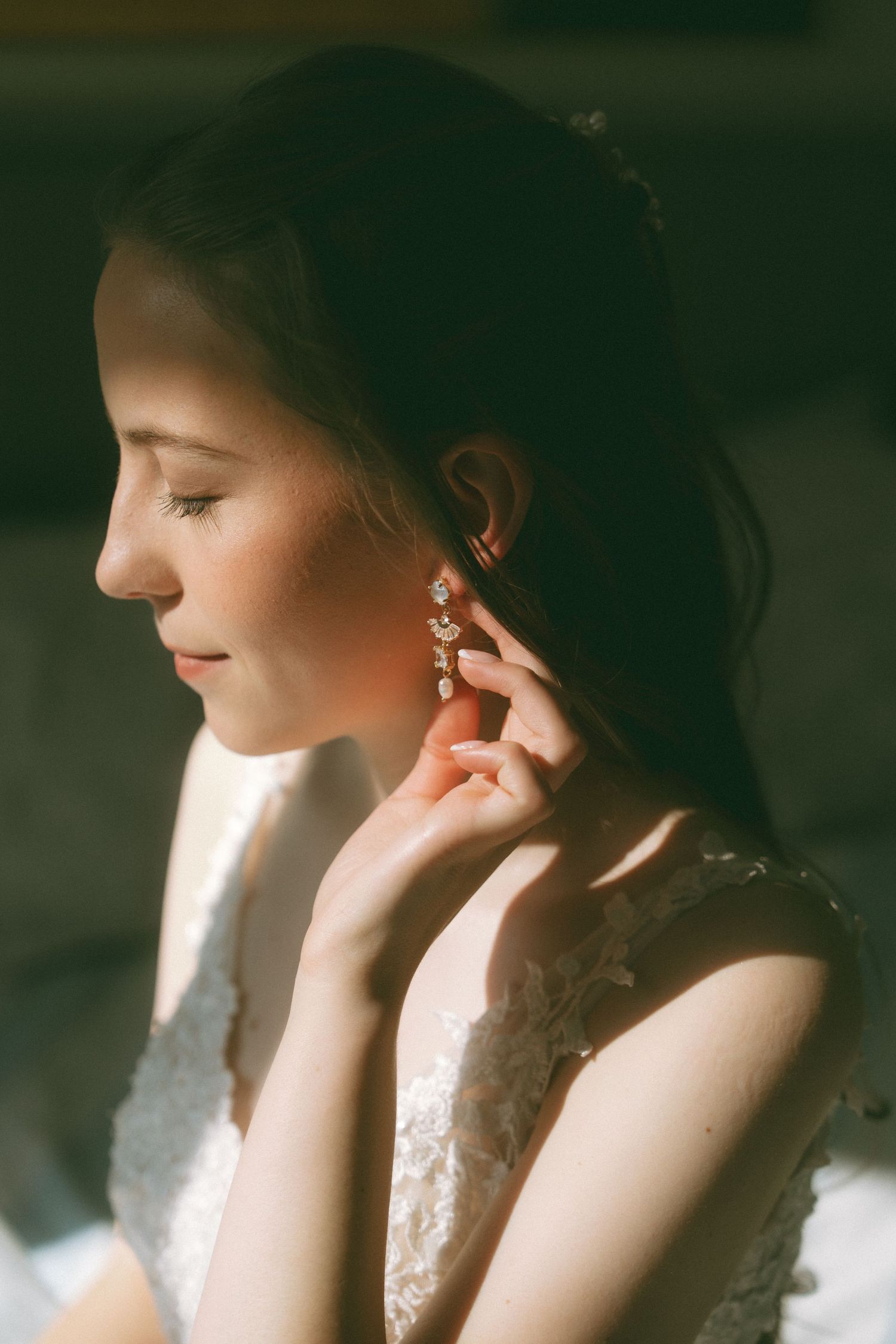 Ethereal bridal portrait with dramatic side lighting and delicate lace details.