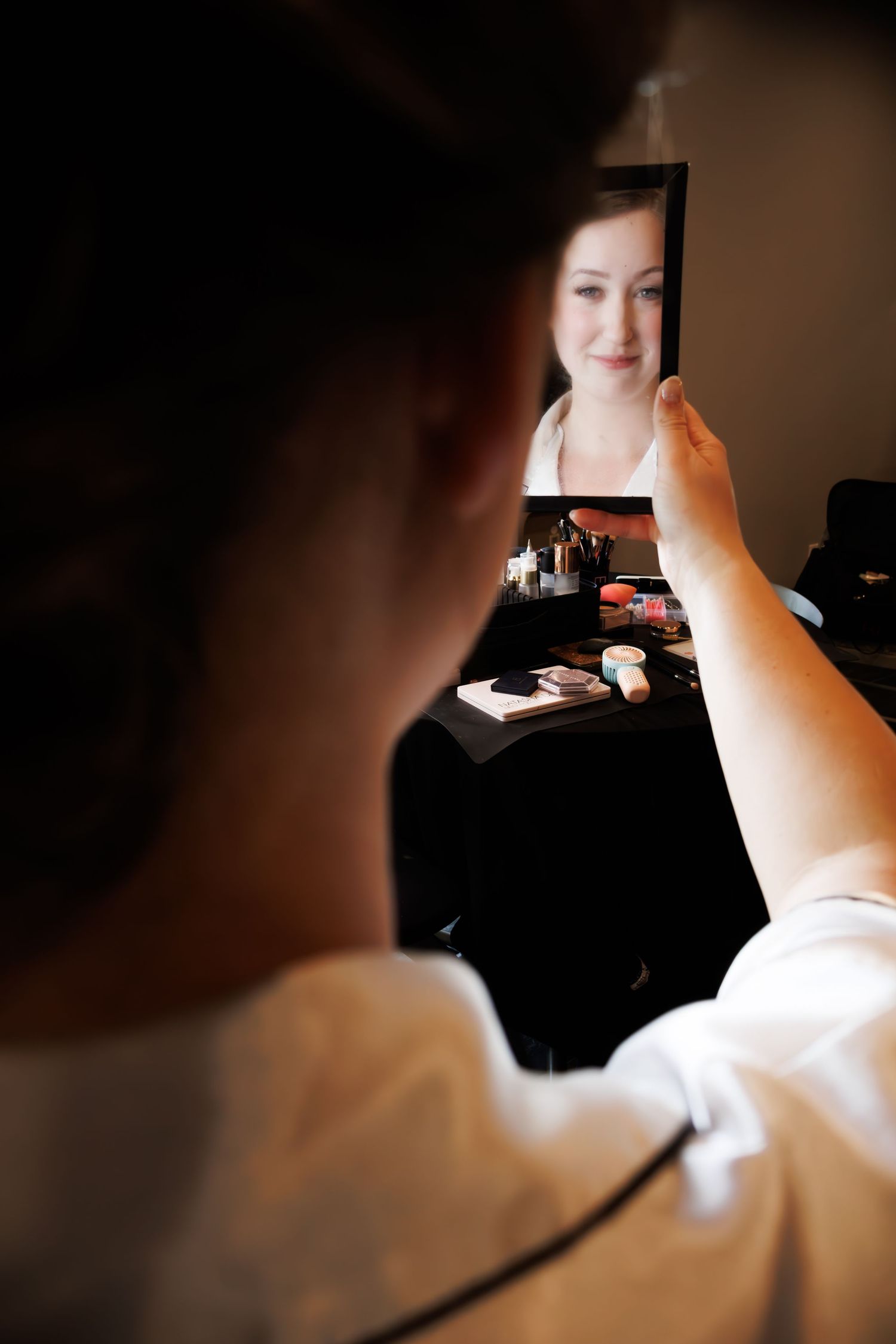 Artistic mirror reflection shot capturing wedding day preparations in soft lighting.