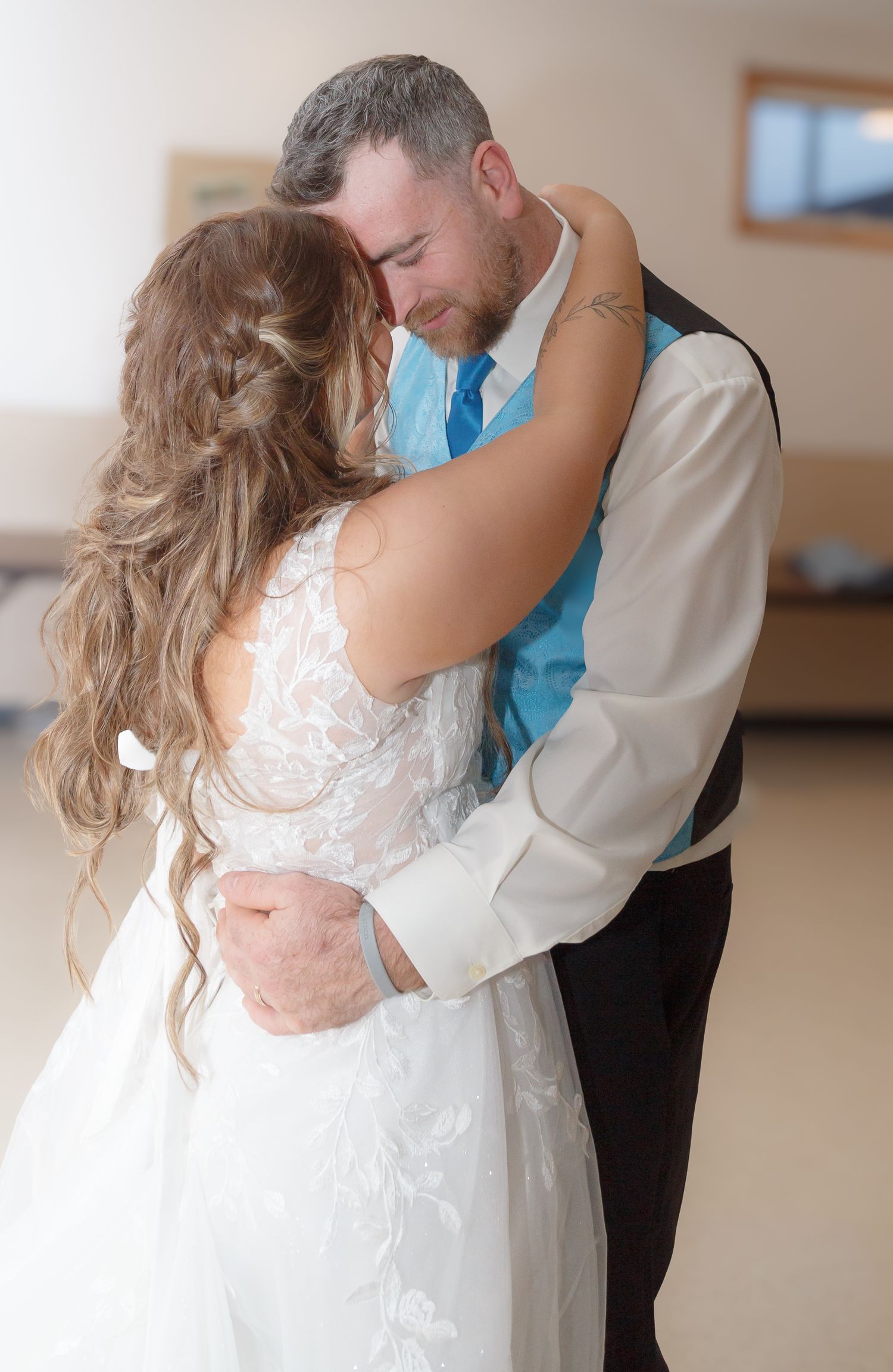 Romantic dance scene with a white wedding dress and formal attire in an indoor venue.