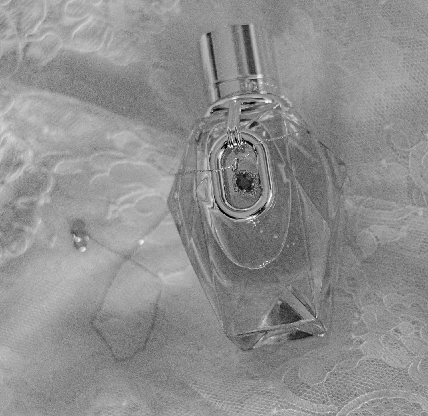 Elegant perfume bottles displayed on delicate white lace fabric.