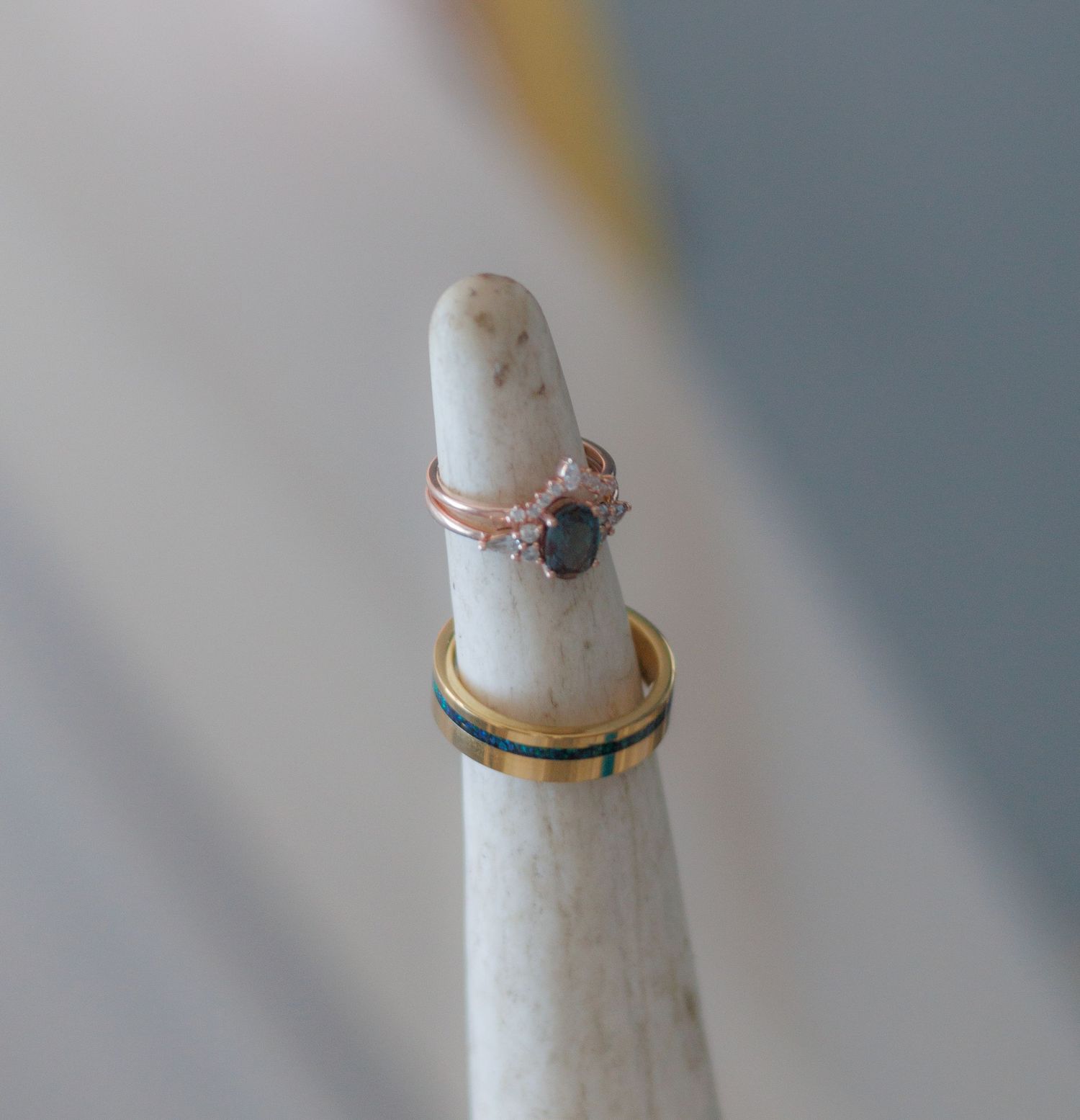 Collection of vintage-style rings displayed on white ceramic ring holders.