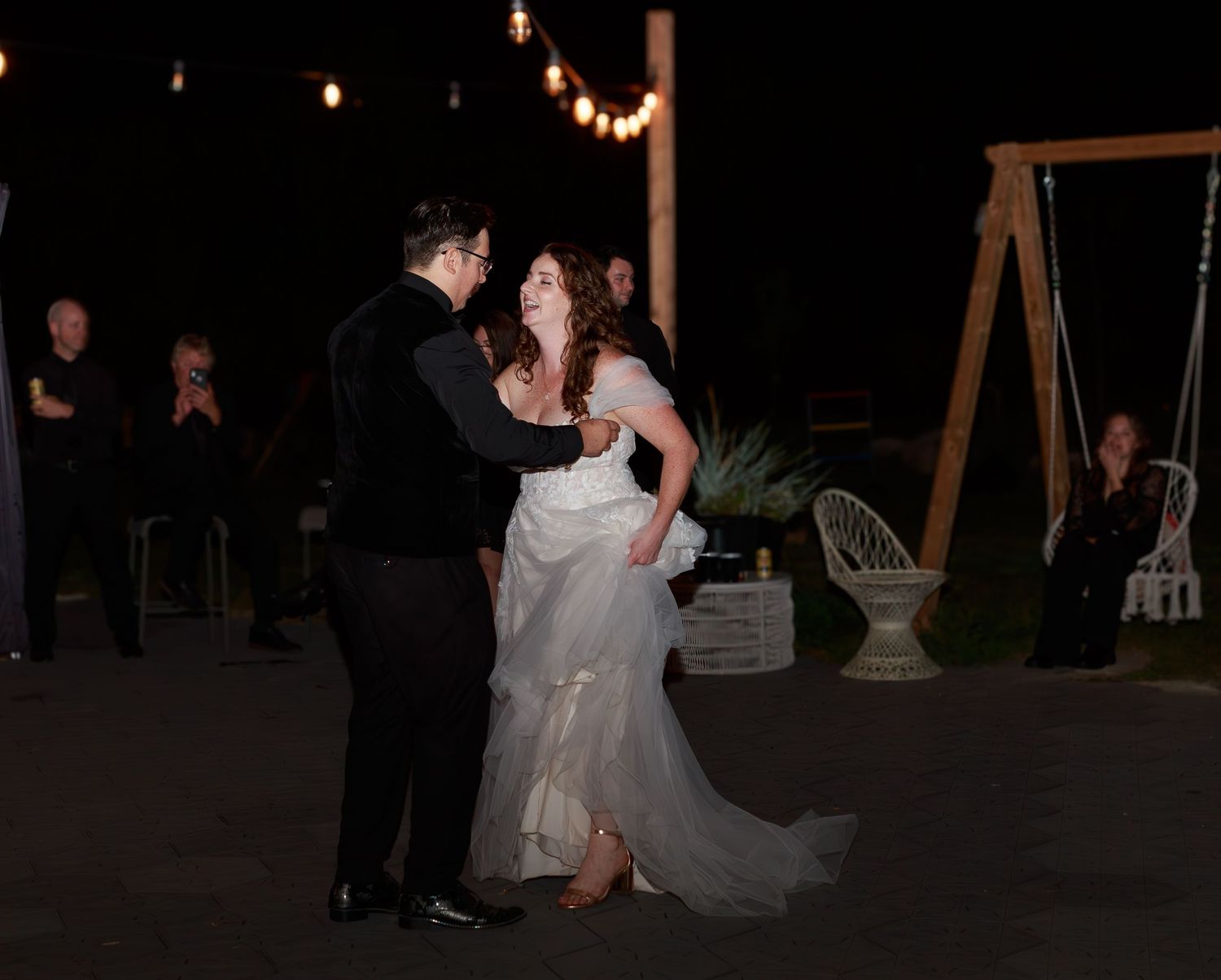 Evening wedding reception with string lights creating a romantic atmosphere.