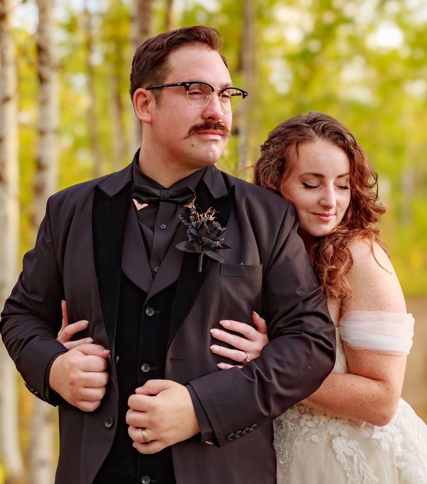 Sweet embraces captured in a sunlit birch forest during an autumn wedding.