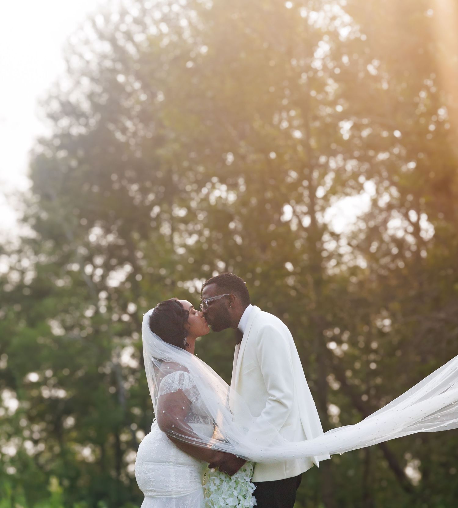 A romantic sunset wedding photoshoot in a golden-lit field.