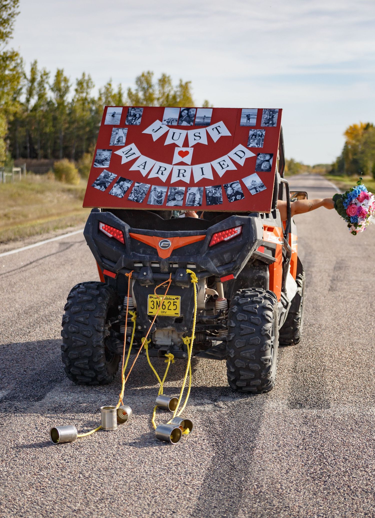 Off-road vehicle decorated with festive banners and streamers parked on a gravel road.