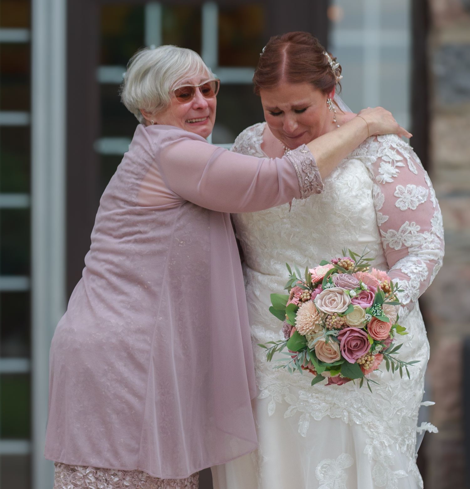 Wedding guests sharing an emotional moment in pink attire.