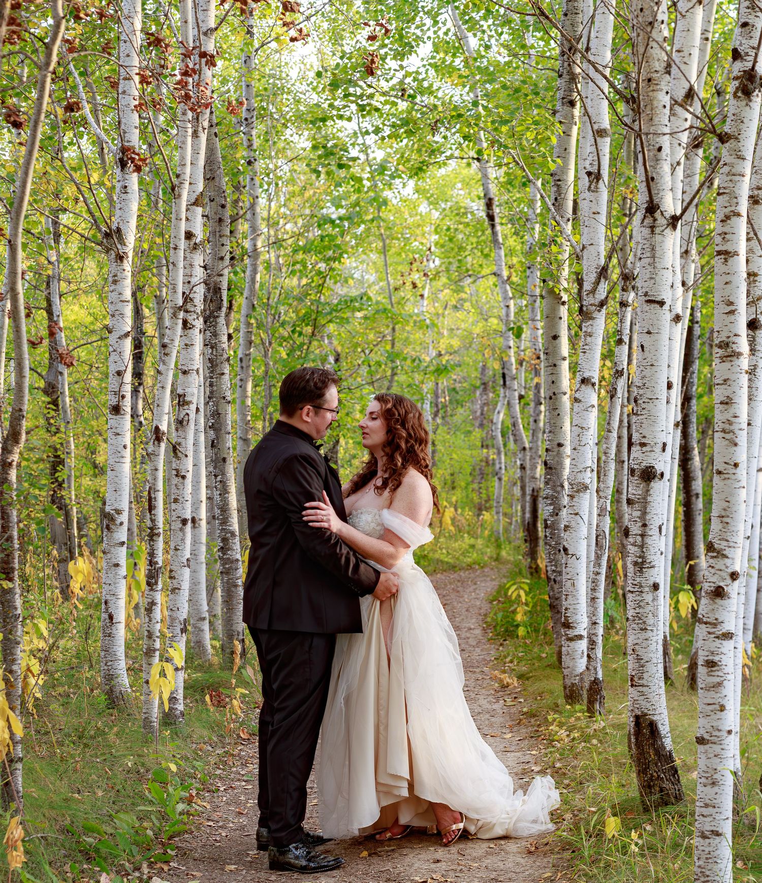 Romantic moment captured in a birch tree forest setting.