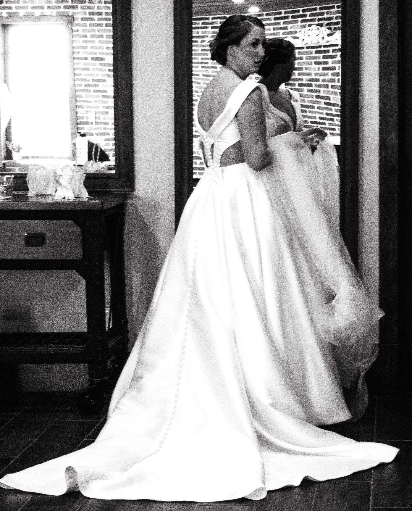 Black and white artistic wedding dress photos against brick wall.
