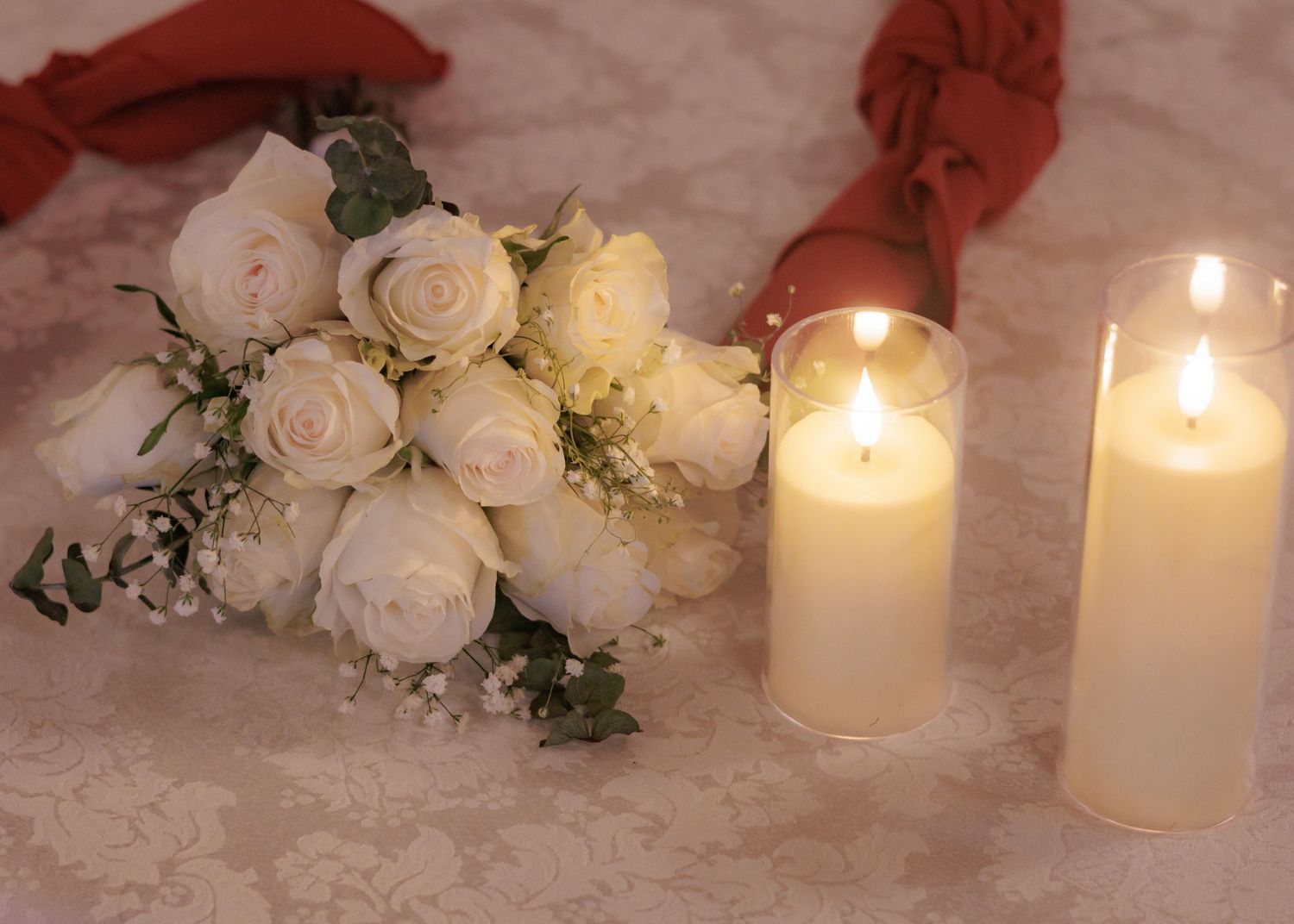 White lit candles and roses create an elegant wedding table setting.