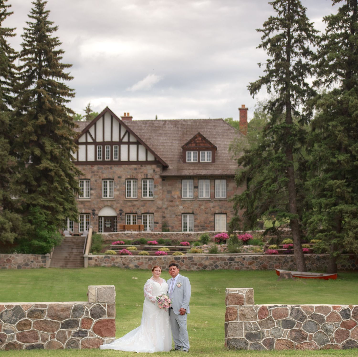 Tudor-style stone mansion with flowering gardens serves as elegant wedding venue.