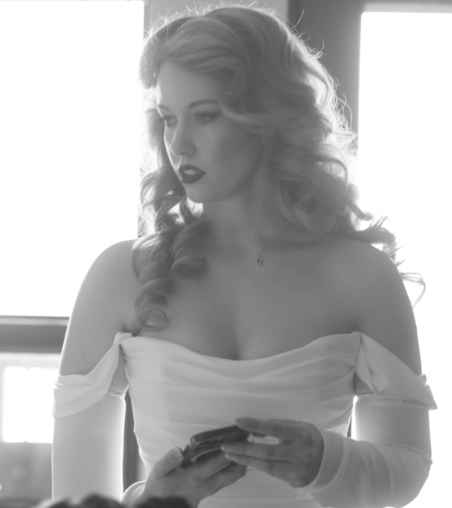 Black and white portrait of bride in off-shoulder wedding dress.