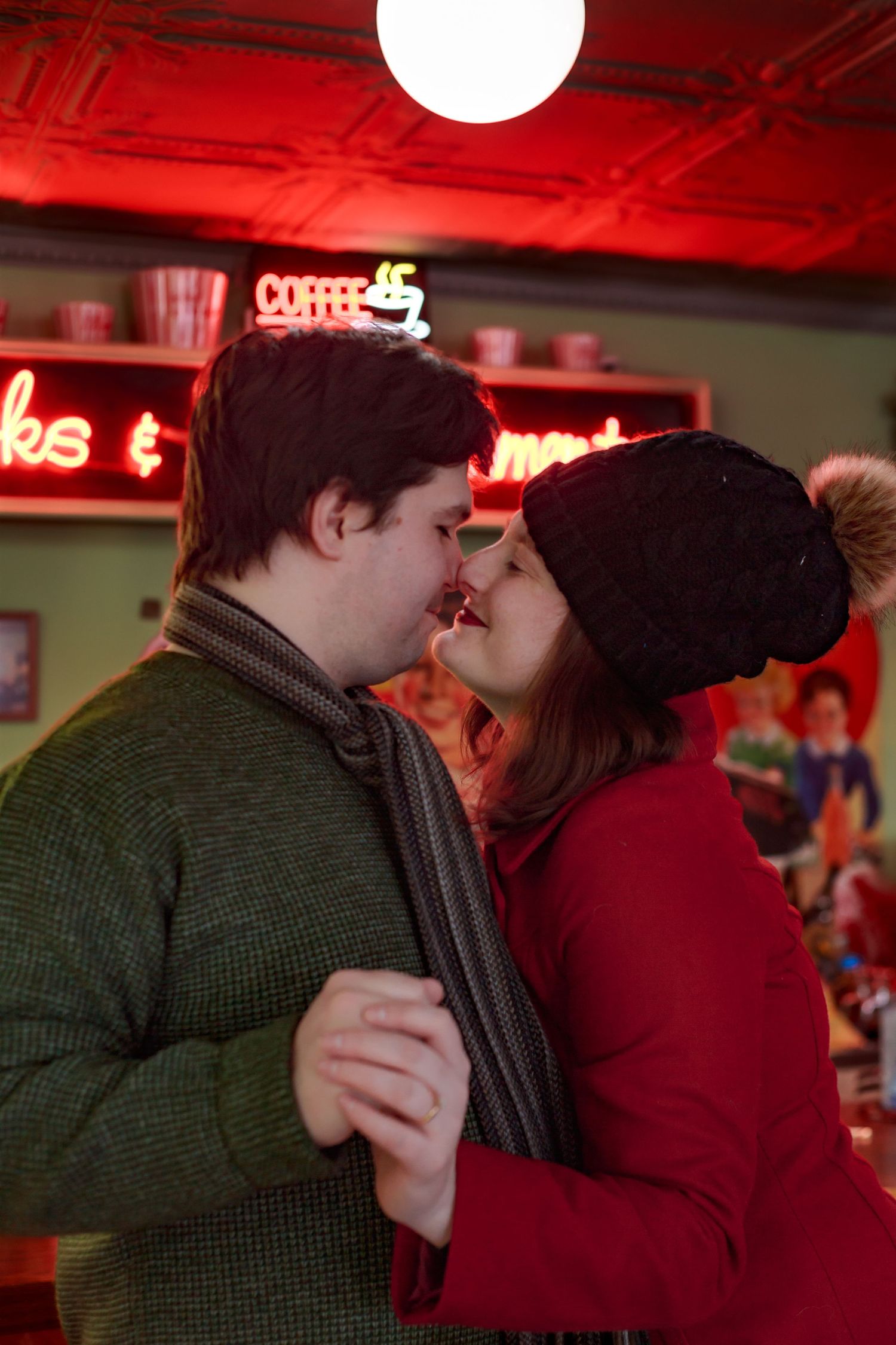 A couple sharing an intimate moment in a dimly lit room with red ambient lighting.