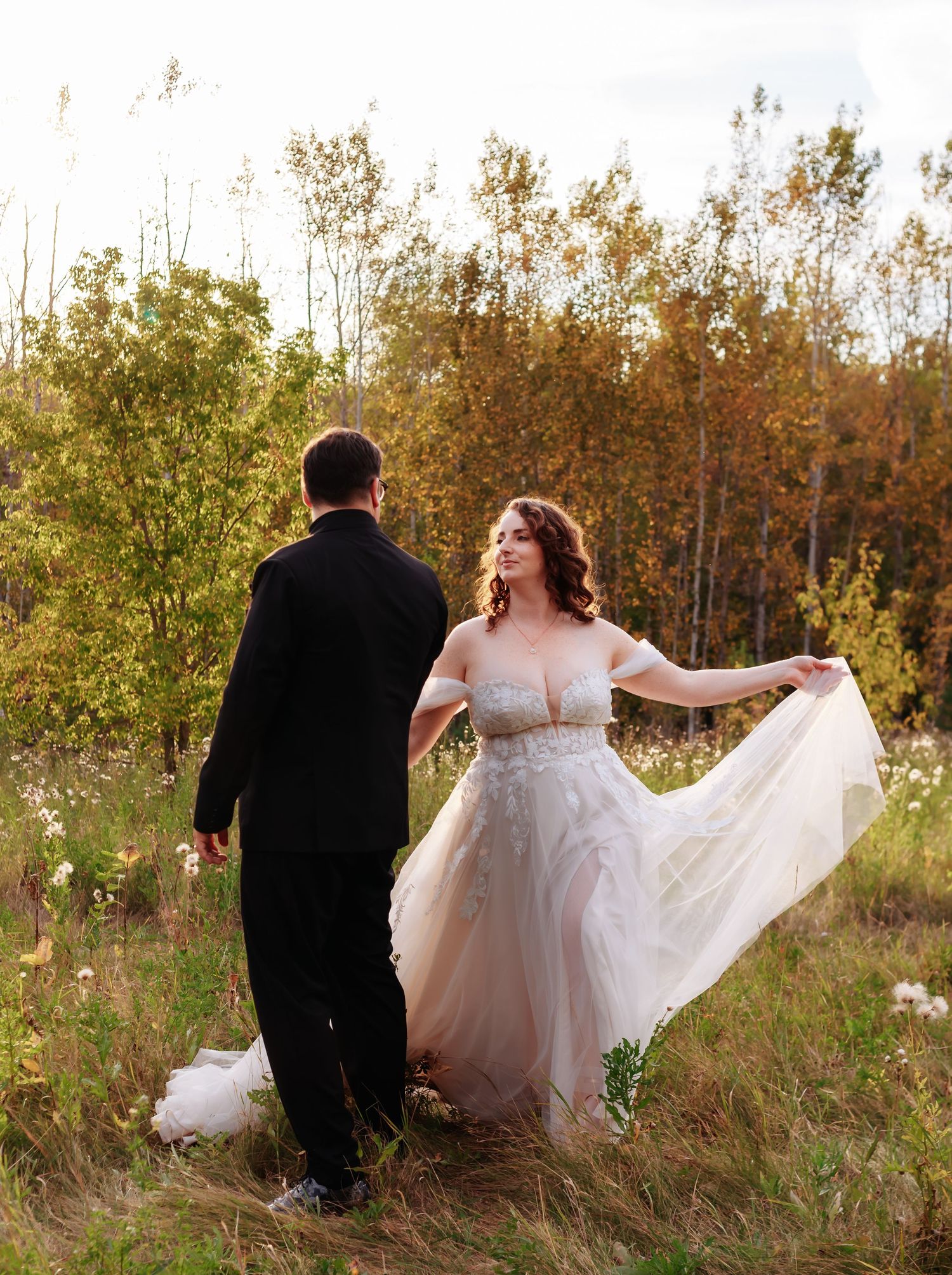 Romantic sunset portraits in a wildflower field with flowing white dress.