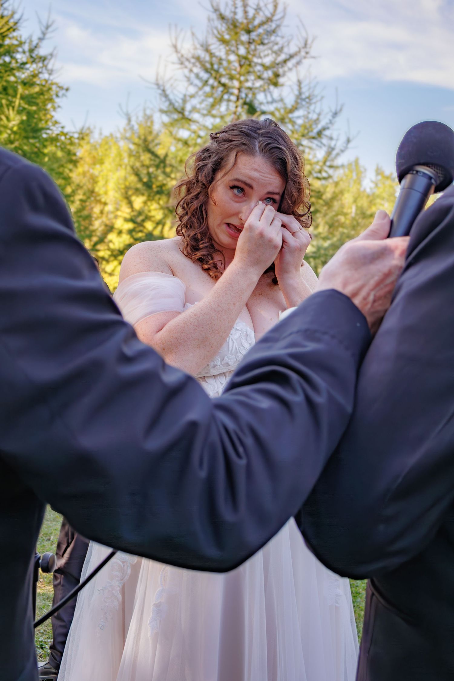 Emotional wedding ceremony moment taking place in a scenic outdoor setting.
