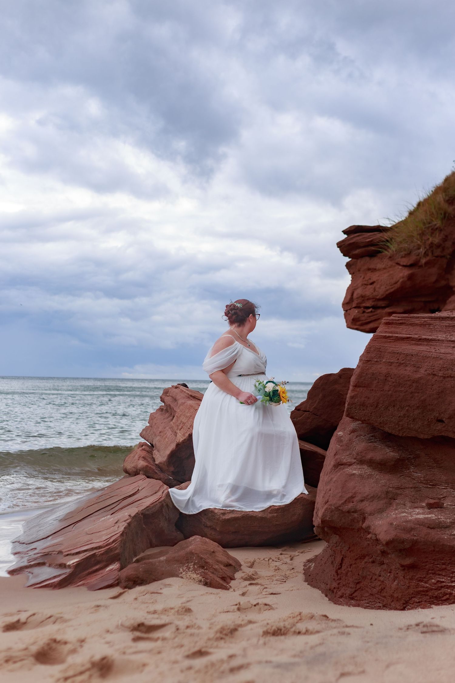 Wedding photography session at red sandstone cliffs overlooking the ocean.