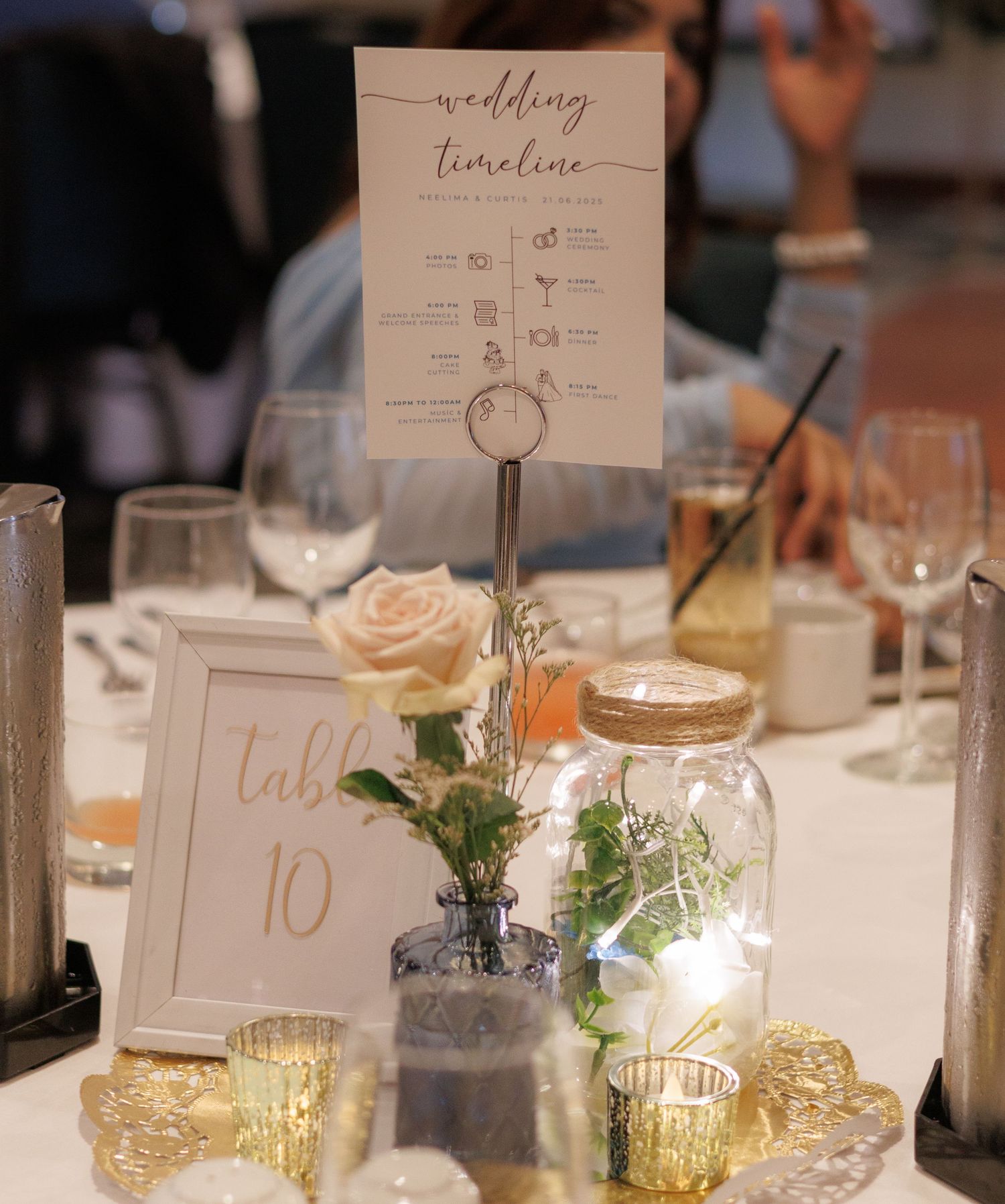 Wedding reception table settings with timeline cards and gold votive candle holders.