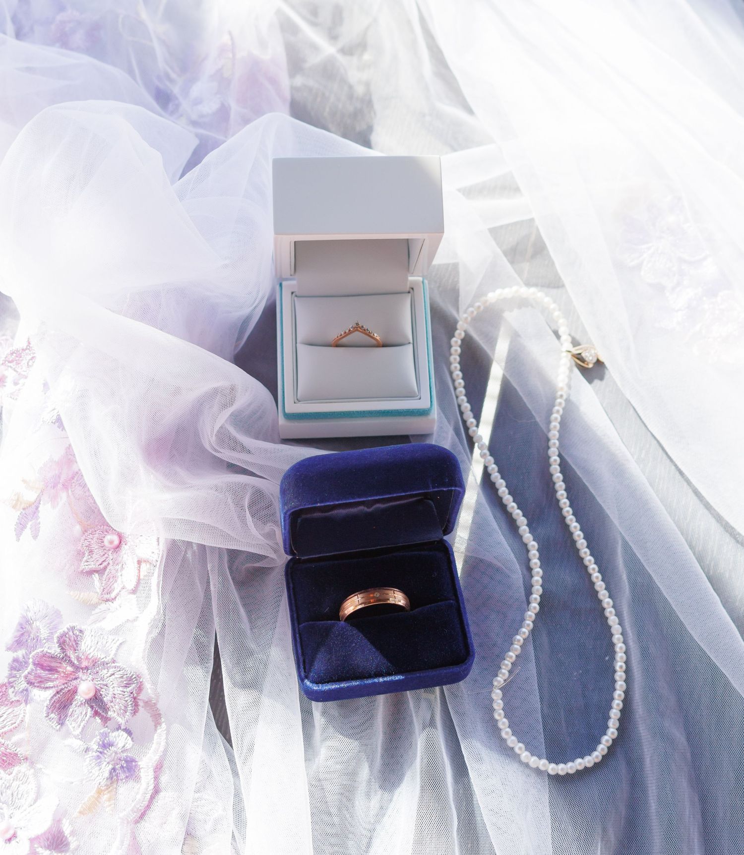 Wedding jewelry and accessories displayed on white tulle fabric with delicate details.