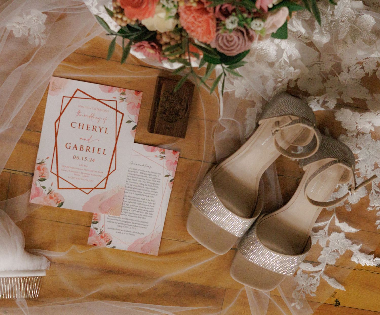 Wedding stationery and details flat lay with pink roses and vintage styling.