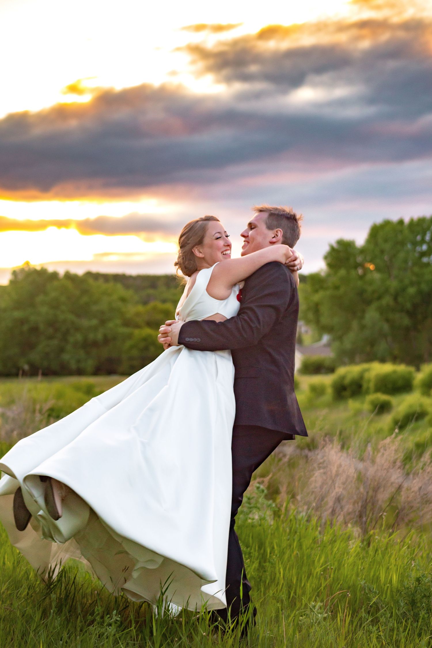 A romantic sunset photoshoot in a meadow with flowing white wedding dress.