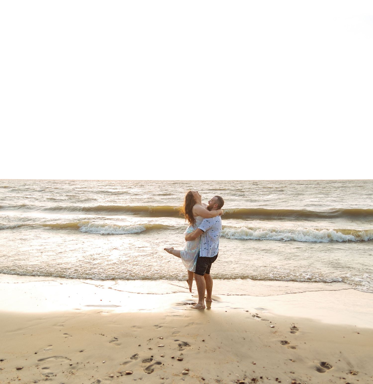 A joyful moment shared between two people on a sandy beach.