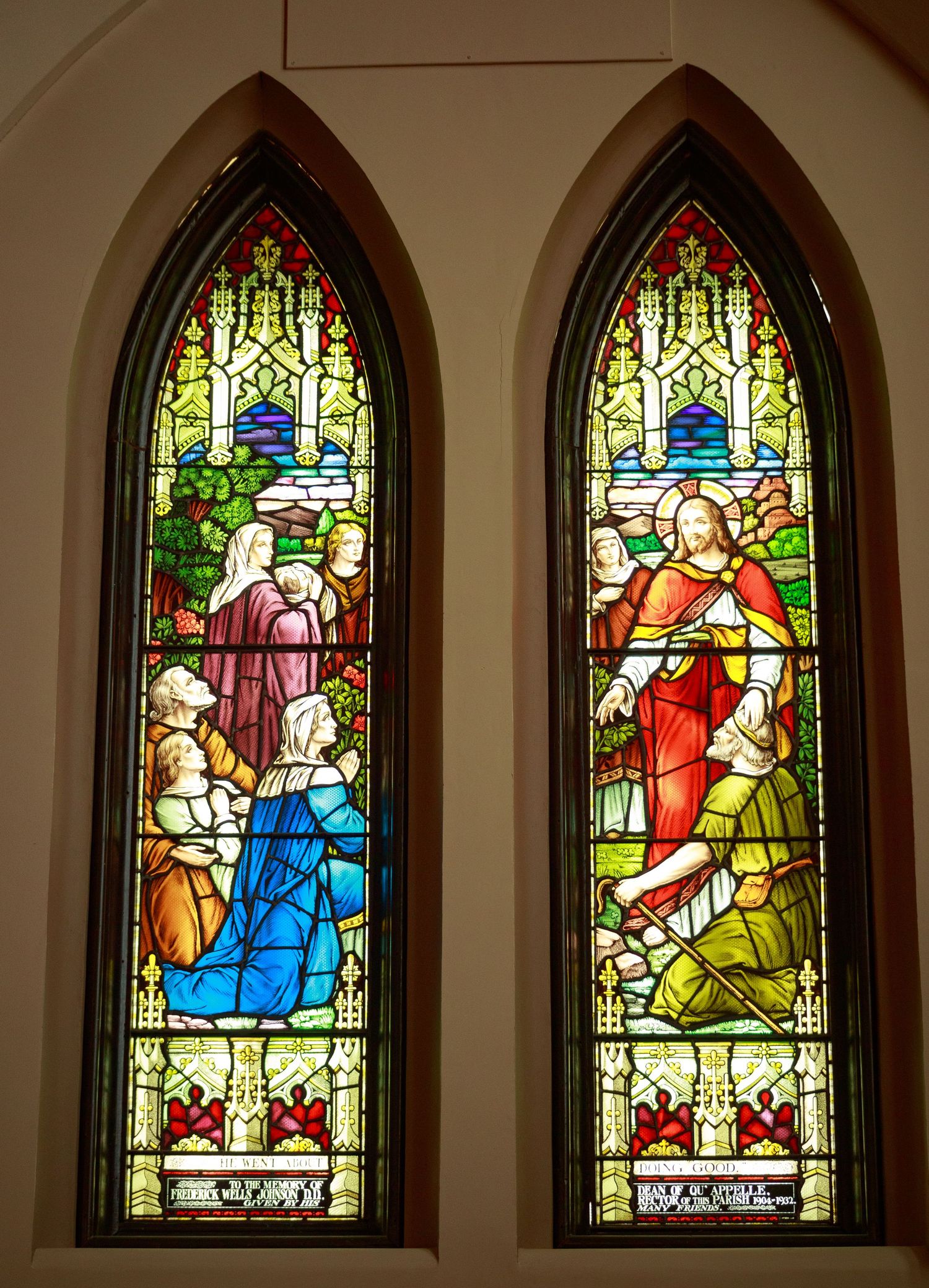 Row of colorful stained glass church windows depicting religious scenes in arched frames.
