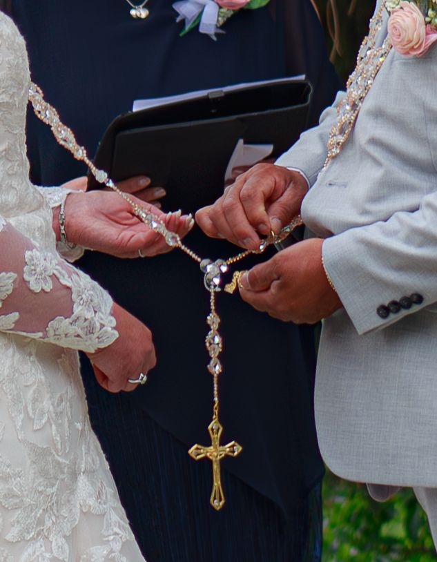 Close-up of hands exchanging wedding rings during a traditional ceremony.