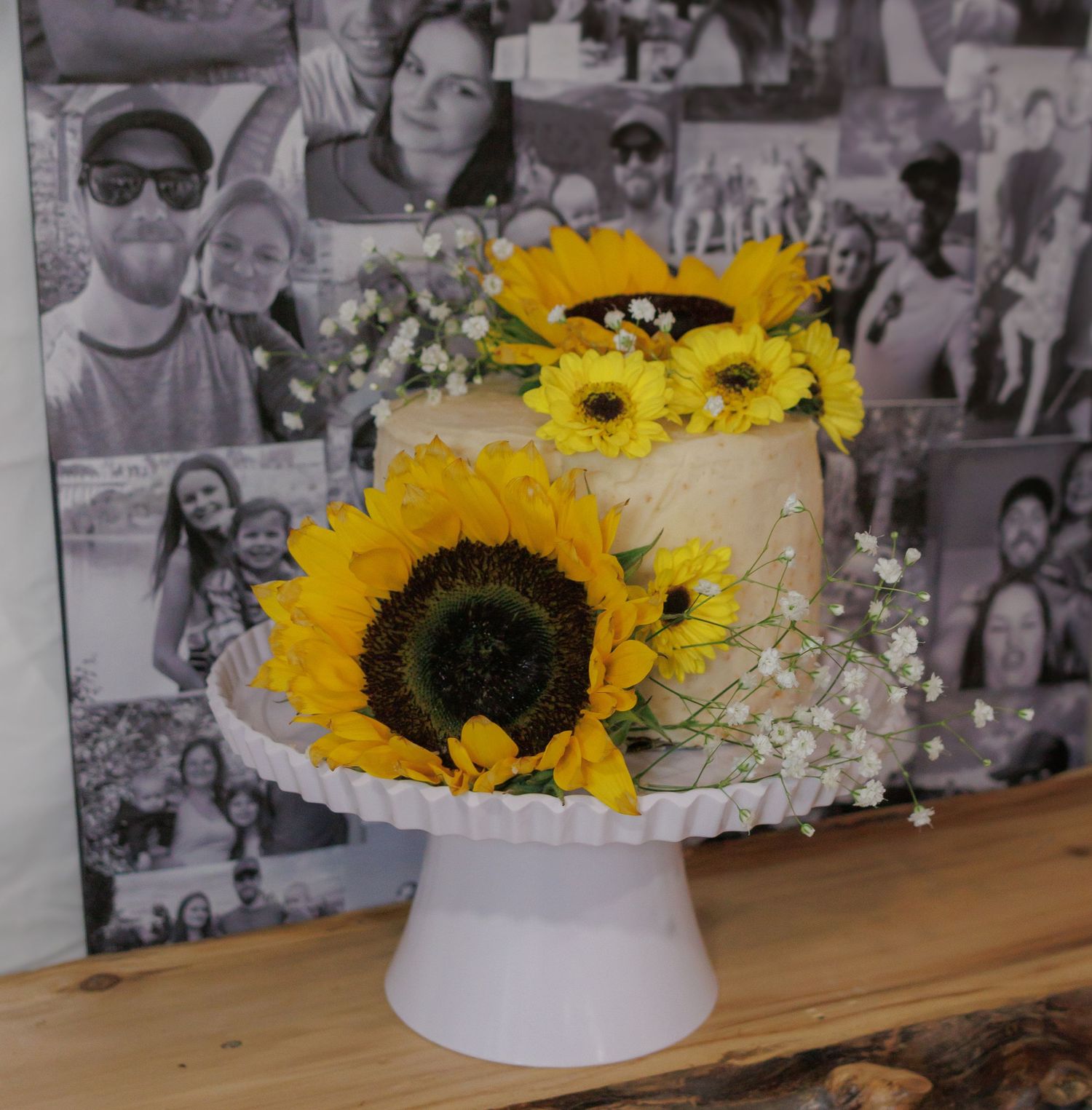 Wedding decorations featuring bright sunflowers and white flowers against a photo wall backdrop.
