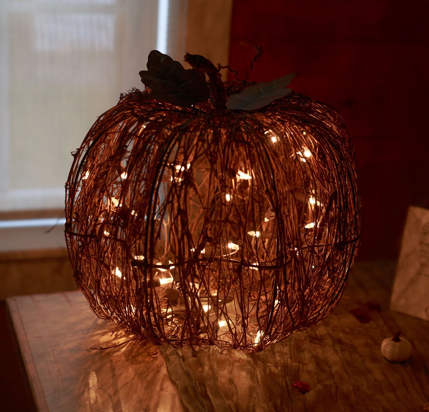 Rustic twig and light decorations create ambient lighting at an indoor wedding reception.