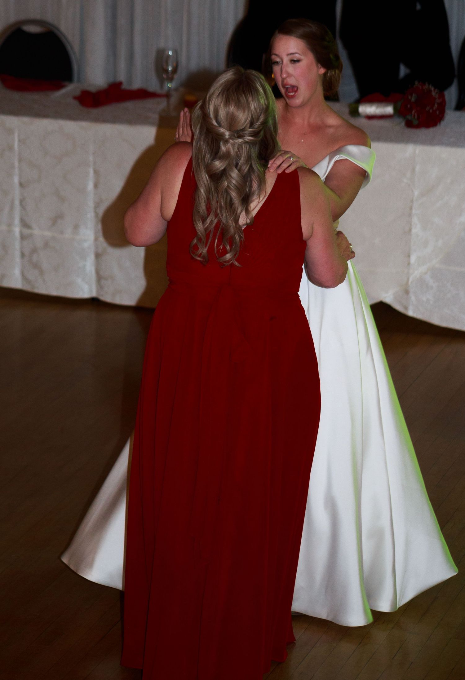 Wedding party dancing in red and white dresses.