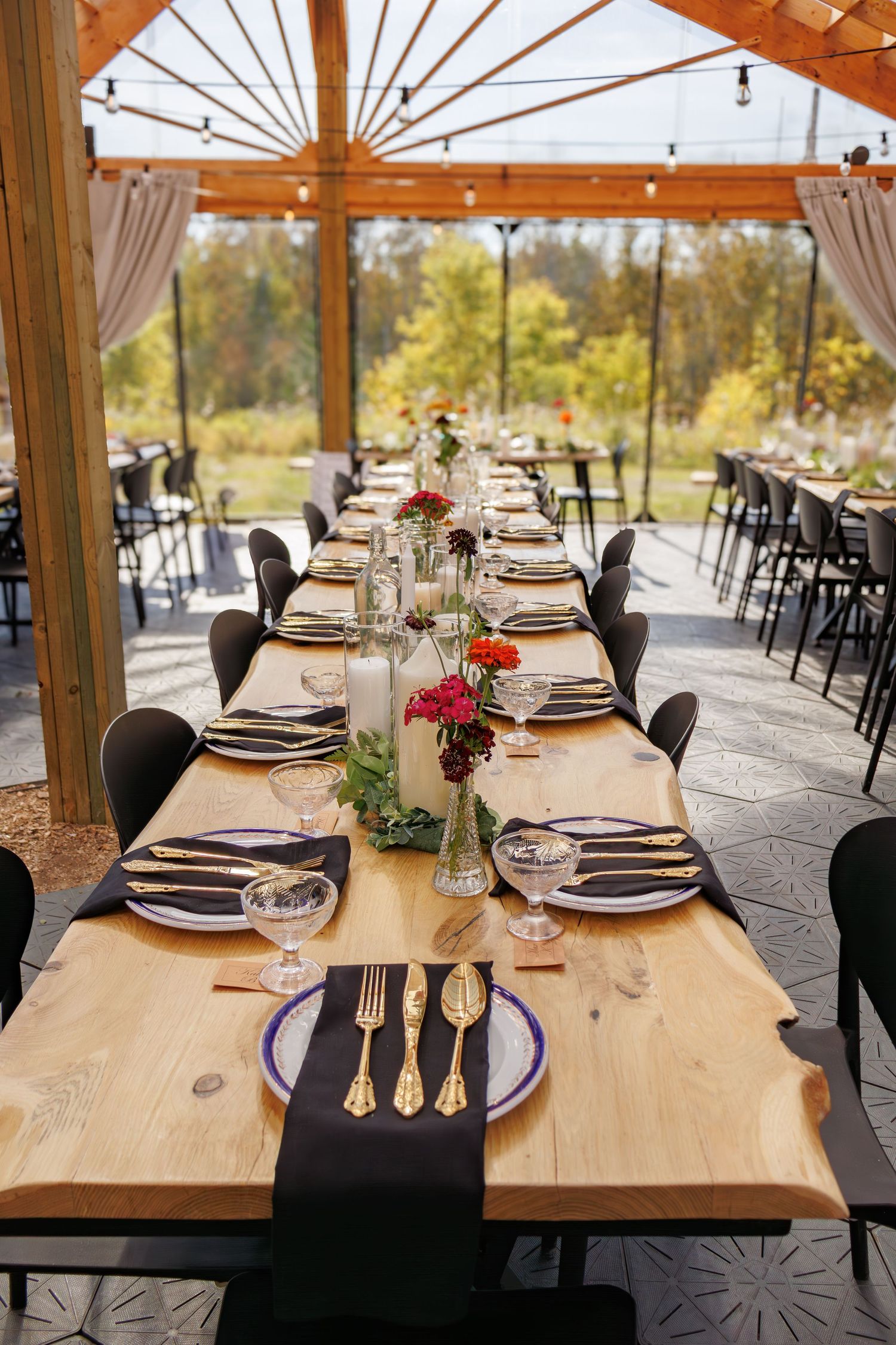 Rustic wooden reception venue with elegant table settings and natural lighting.