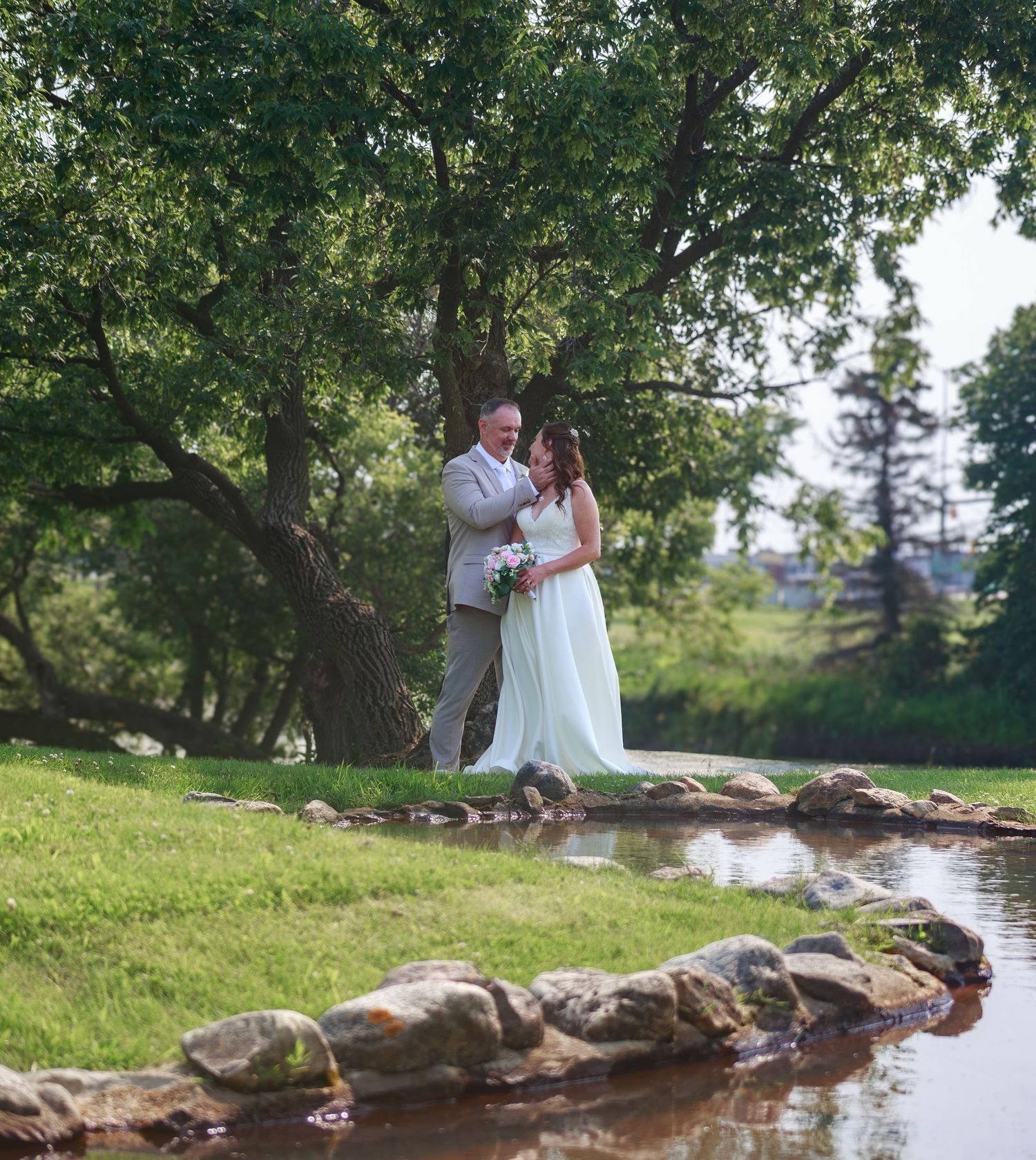 Scenic creek with stone embankment and lush greenery in a natural outdoor setting.