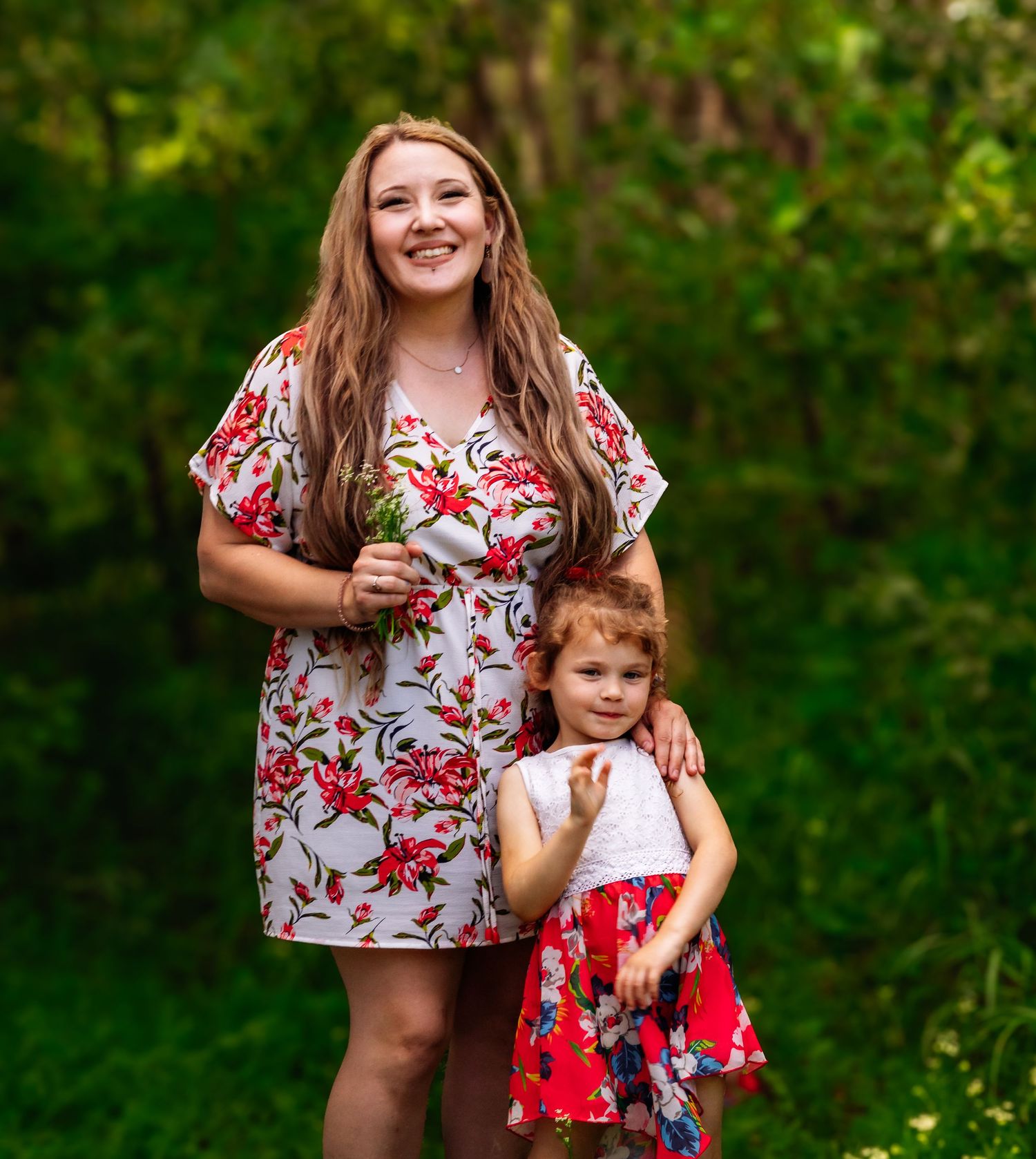A floral dress photoshoot in a lush green garden setting during summer.