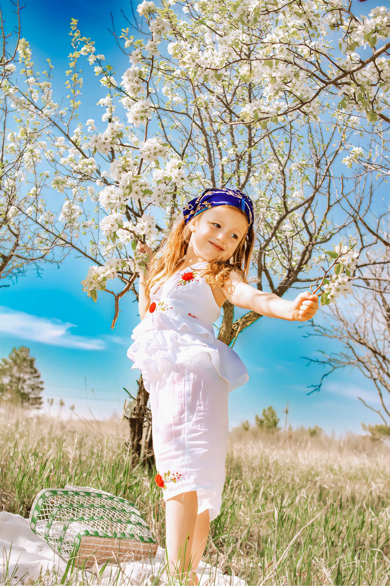 Child playing in blooming cherry blossom trees on a bright spring day.