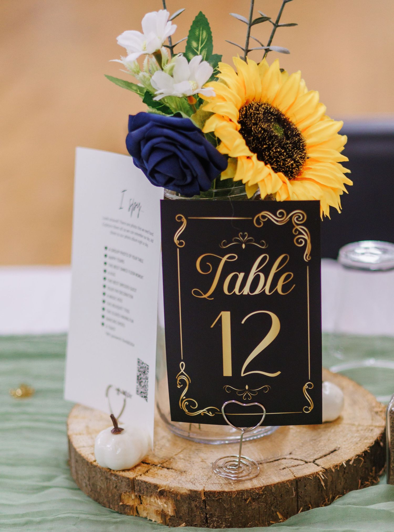 Rustic wedding table numbers with sunflowers on wood slices as centerpieces.
