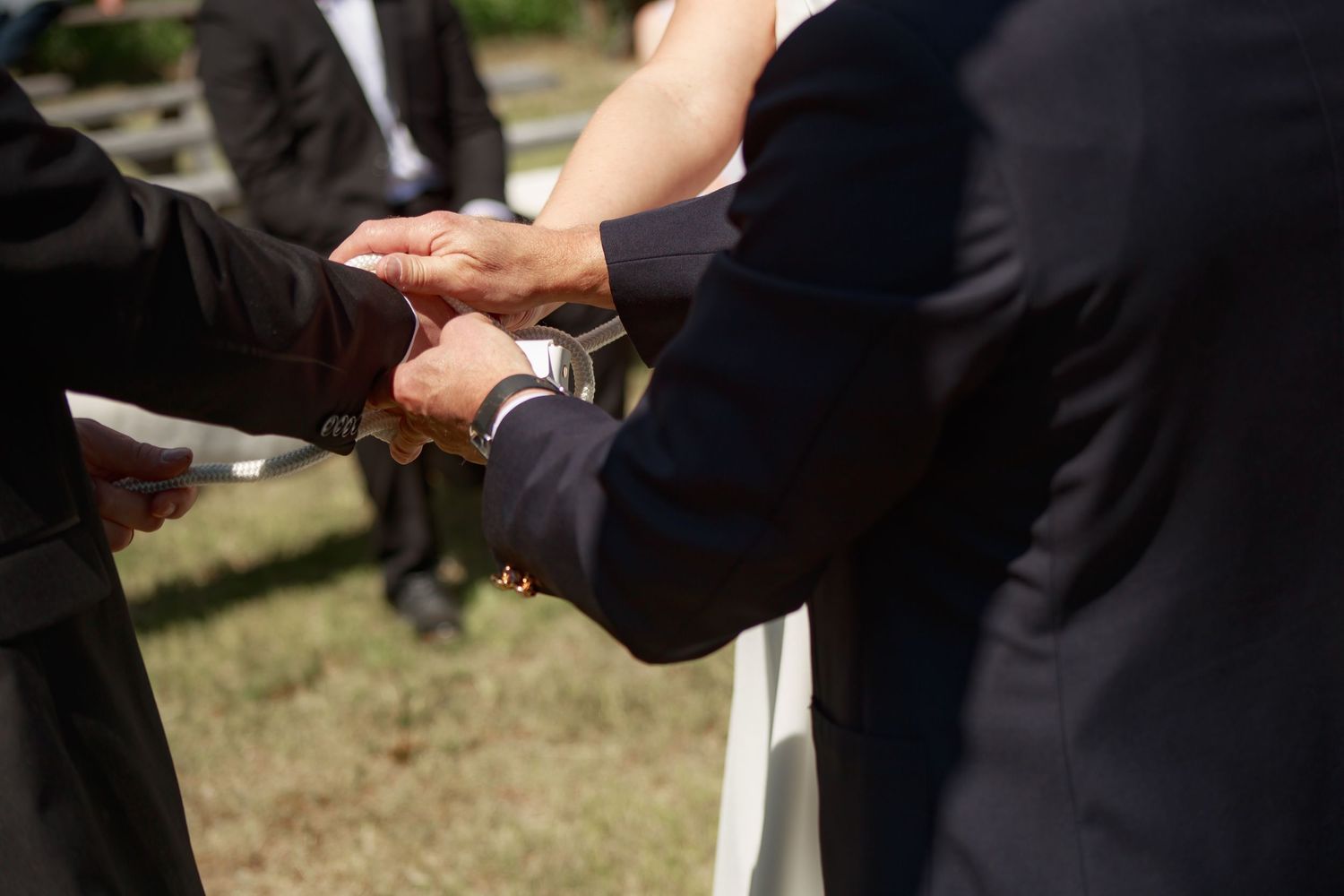 Close-up of hands during wedding ceremony exchange.