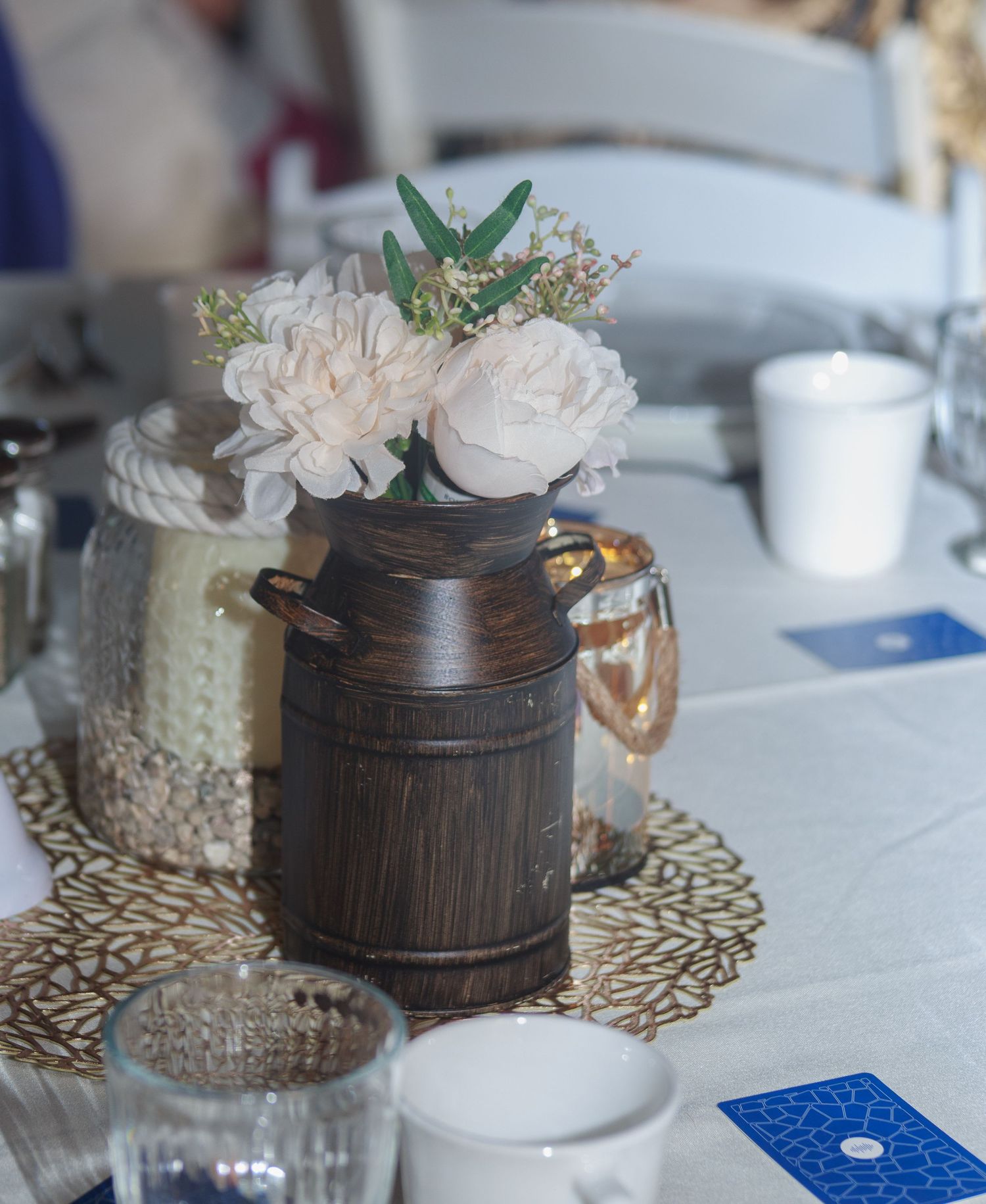 Rustic wooden barrel vases with delicate floral arrangements displayed on decorative doilies.