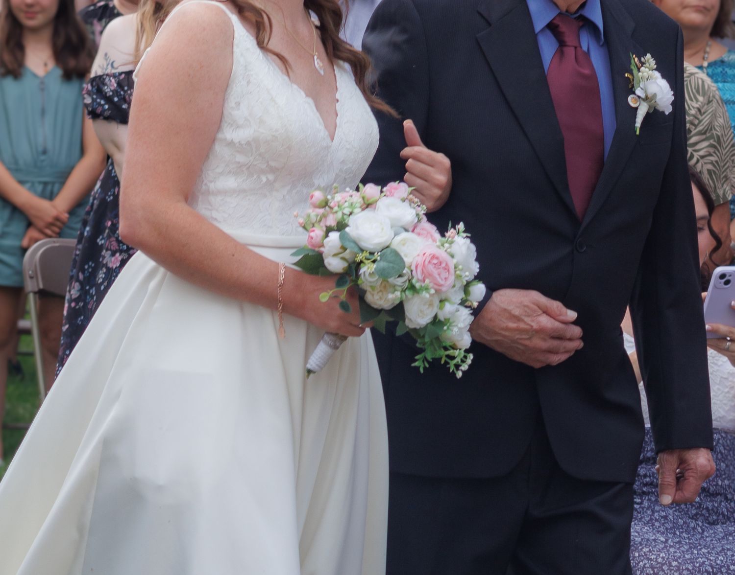 Wedding ceremony processional with bouquet and formal attire.
