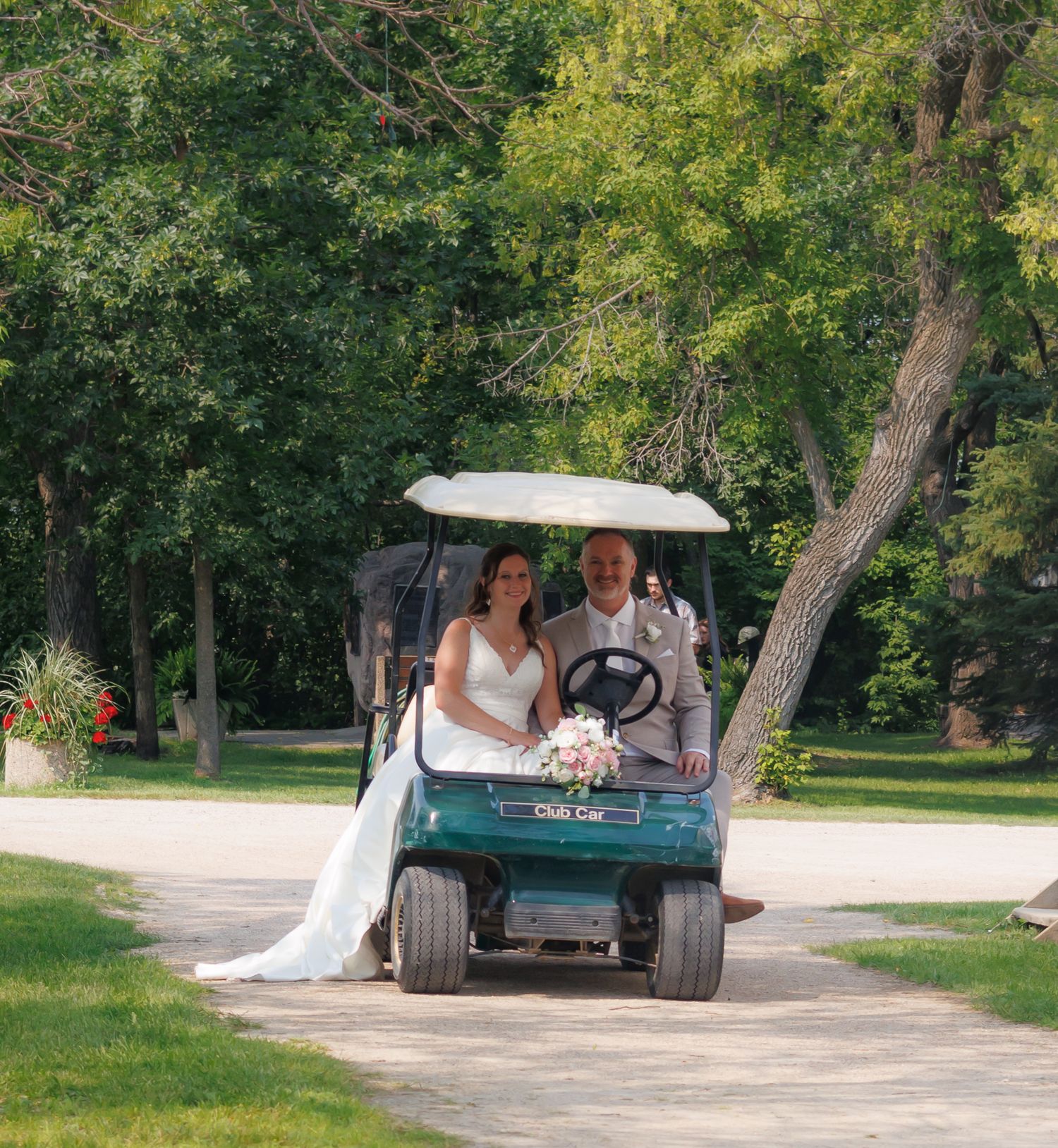 Outdoor wedding scene with vintage truck under shady trees.