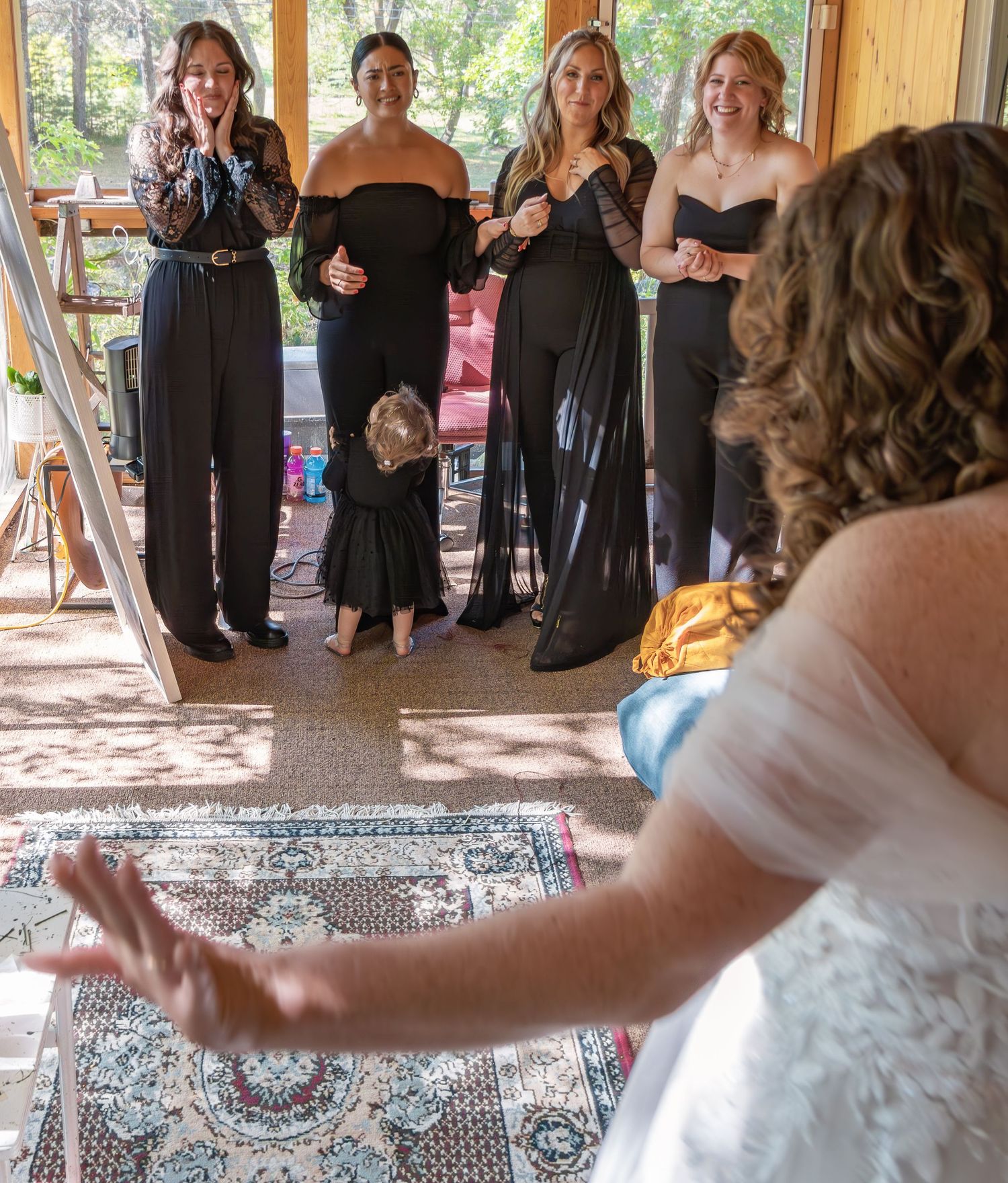 Wedding party dancing and celebrating in a rustic wooden venue with natural lighting.