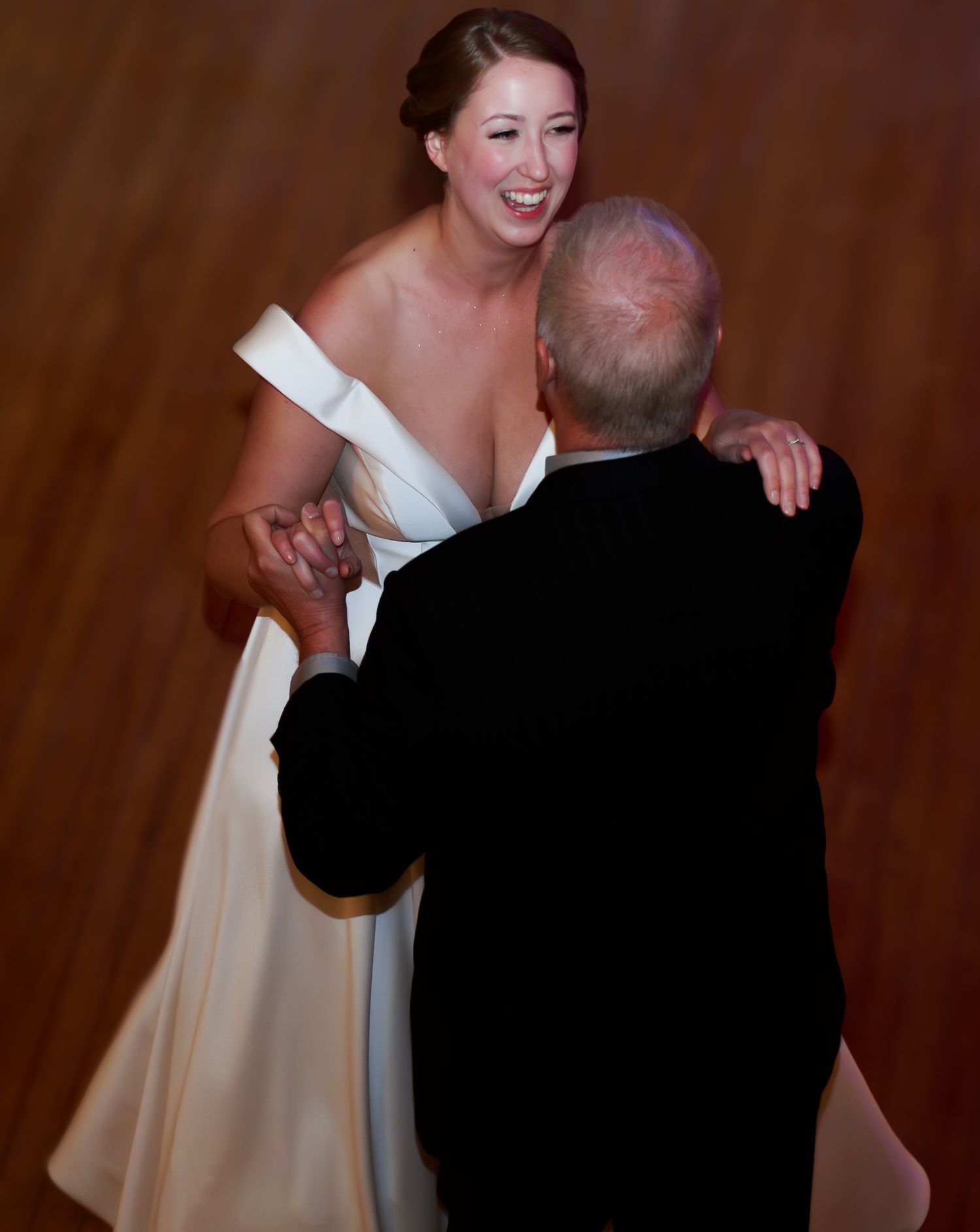 Joyful wedding dance moment in an elegant reception venue.
