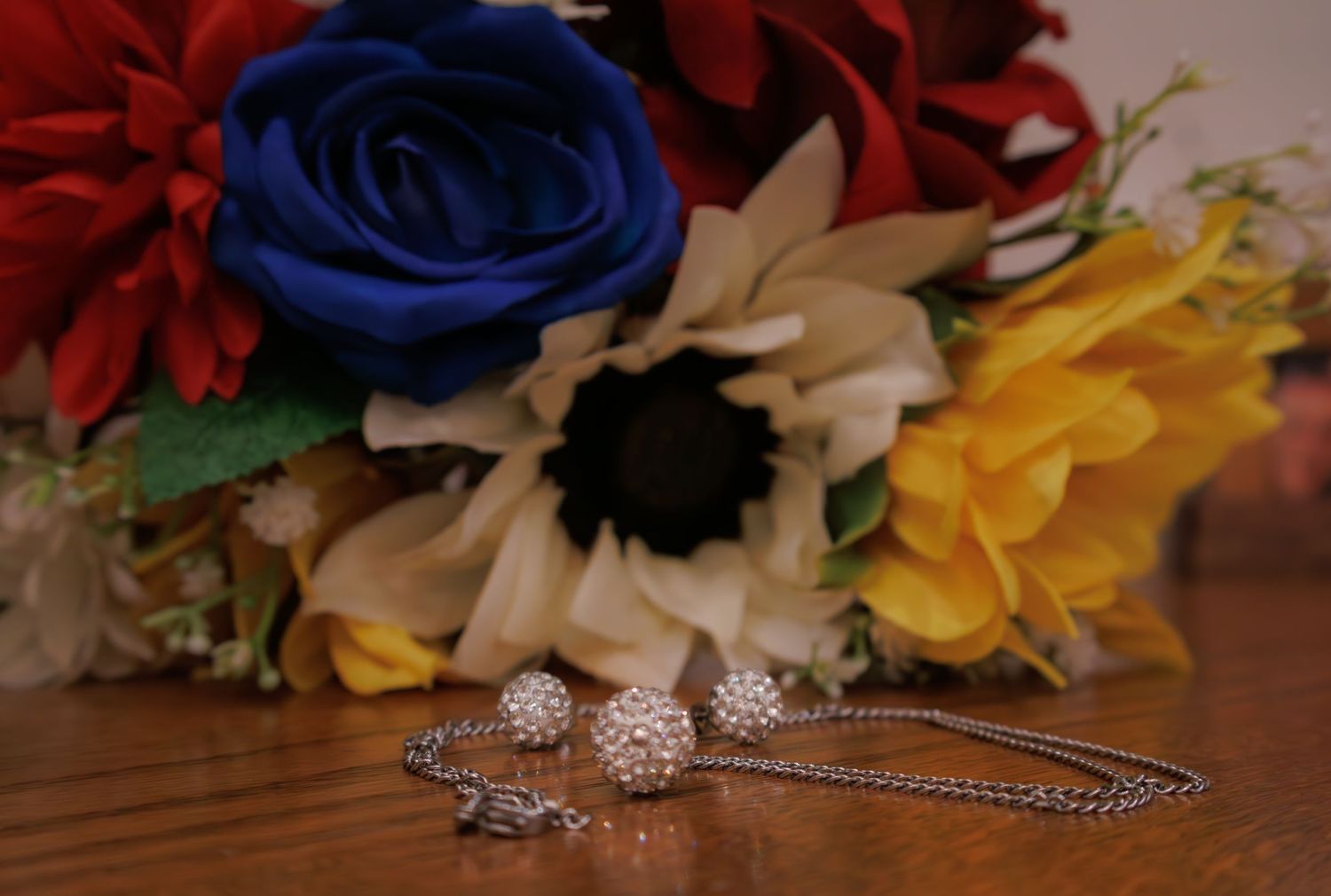 Colorful wedding flowers and decorative accessories arranged on a wooden surface.