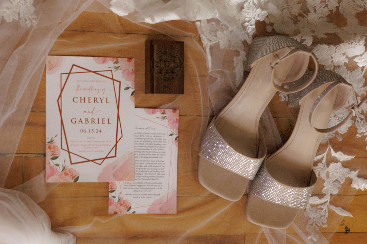Wedding details featuring an invitation with floral design, heels, and lace veil on peach background.