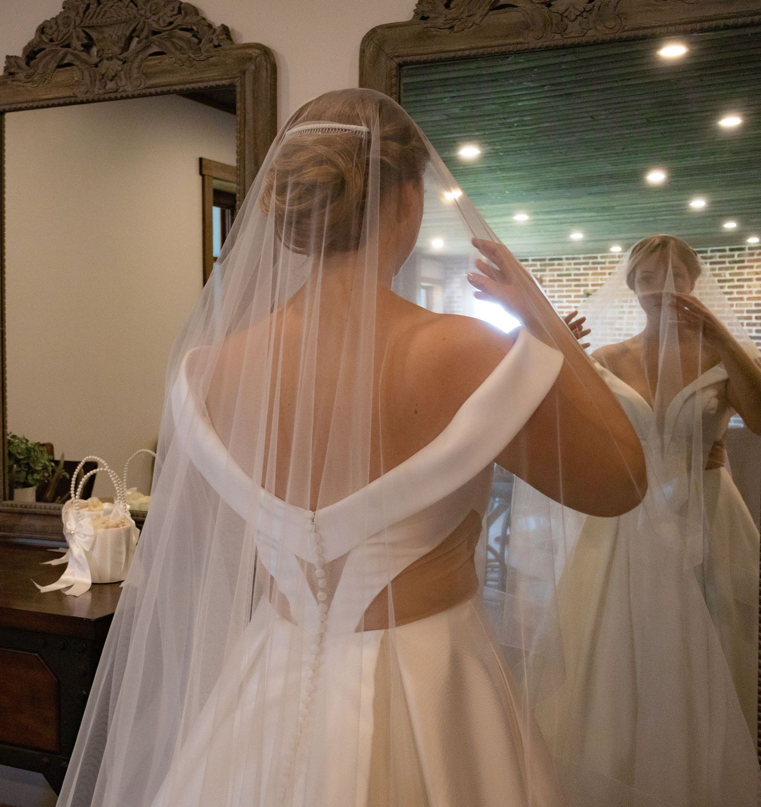 Wedding dress preparations with flowing veil in a bridal boutique.
