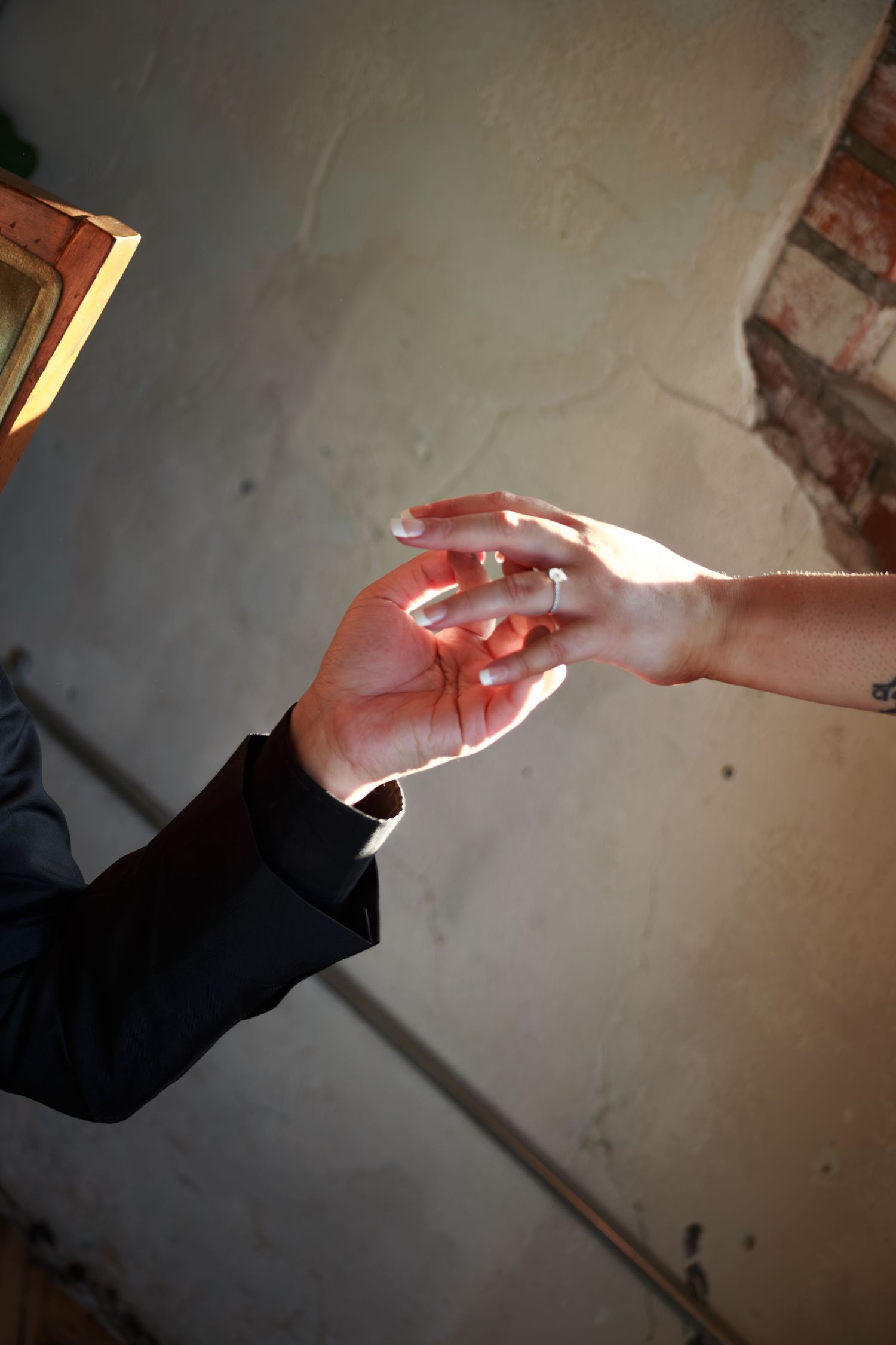 Close-up sequence of hands passing a small object in dim lighting.