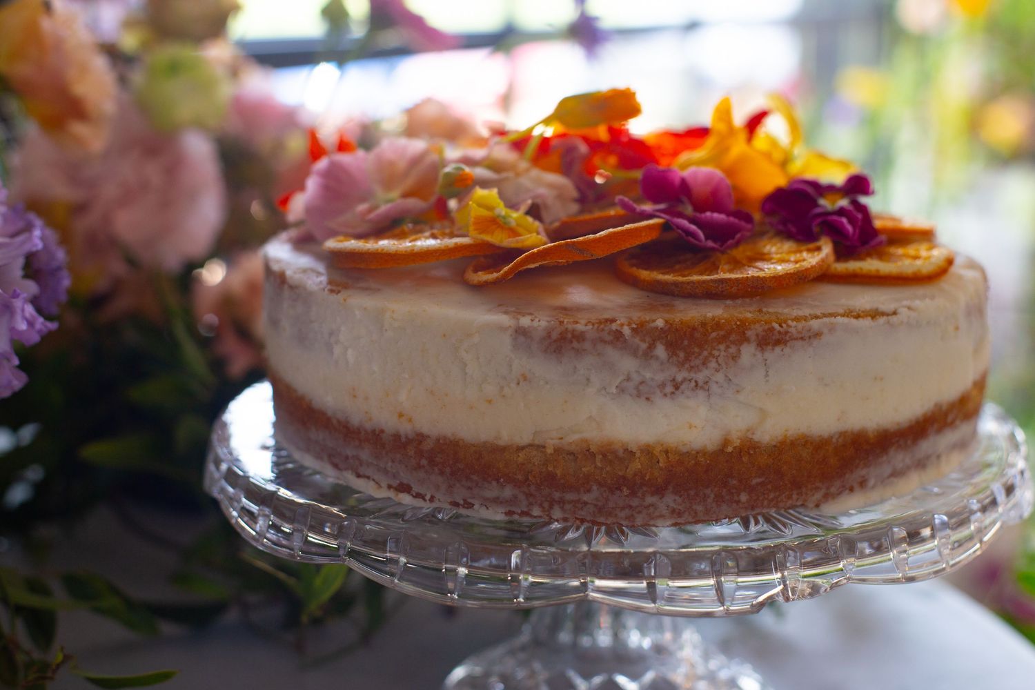 Elegant dessert table with cheesecakes and colorful floral decorations at a wedding reception.